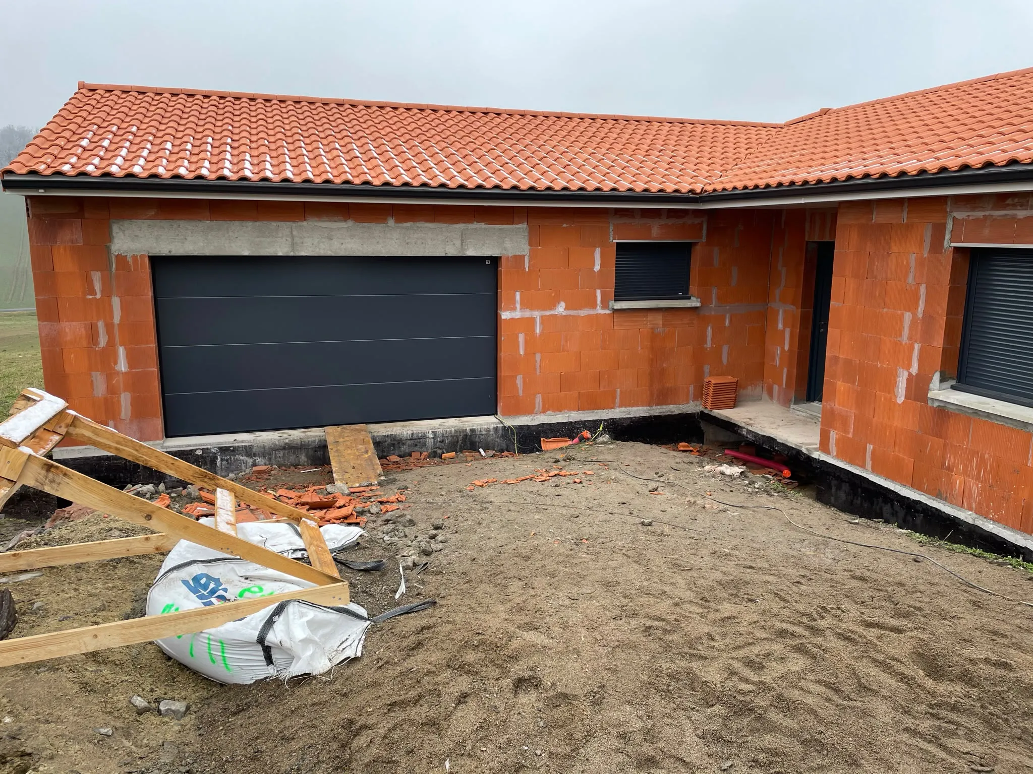 Large porte de garage sombre sur une construction — AFermetures