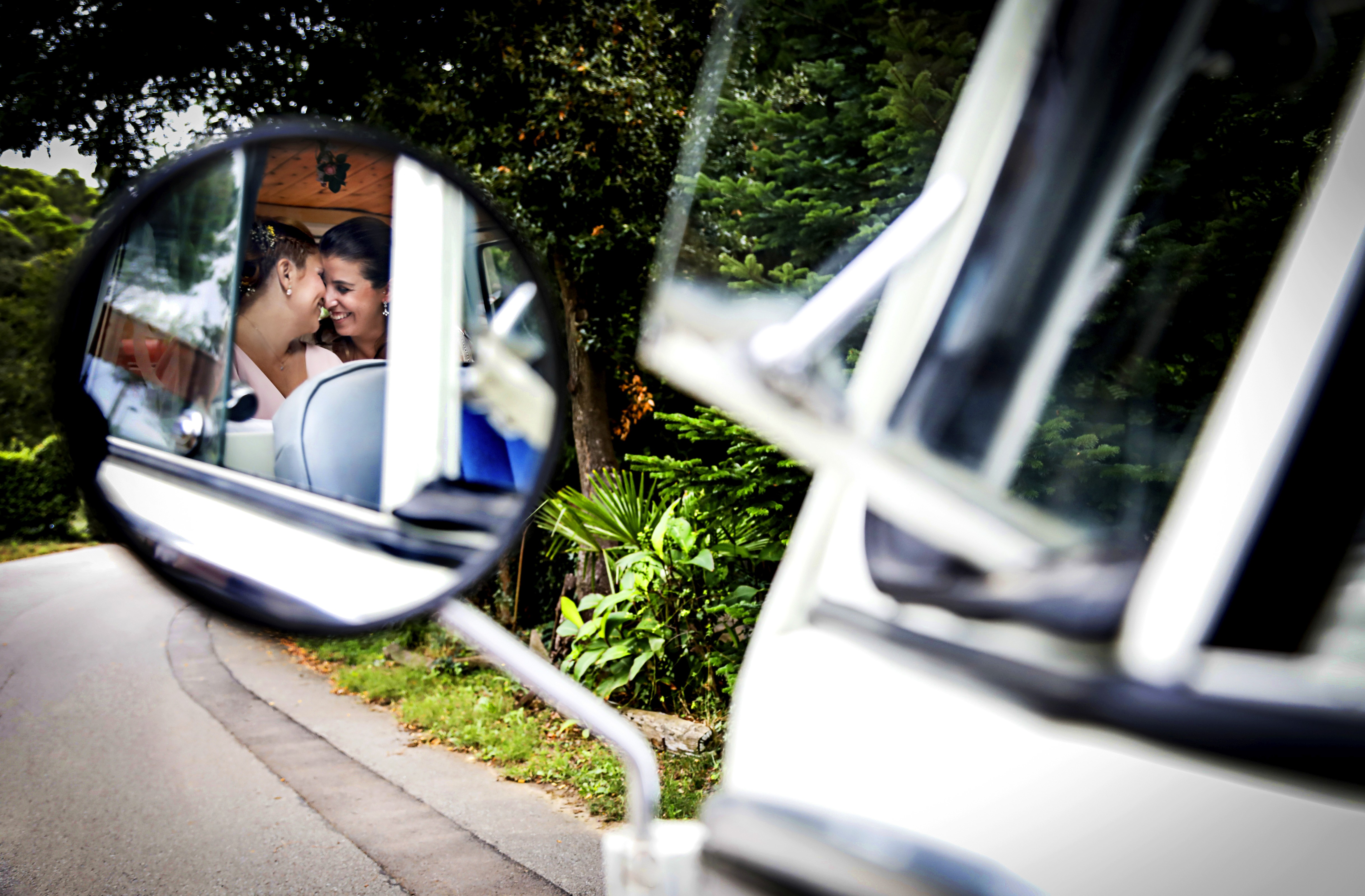Sesión de boda. Pareja que se ve a través del retrovisor.