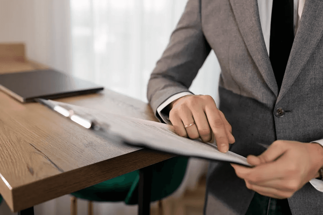 Professional reviewing a job application on a wooden desk.