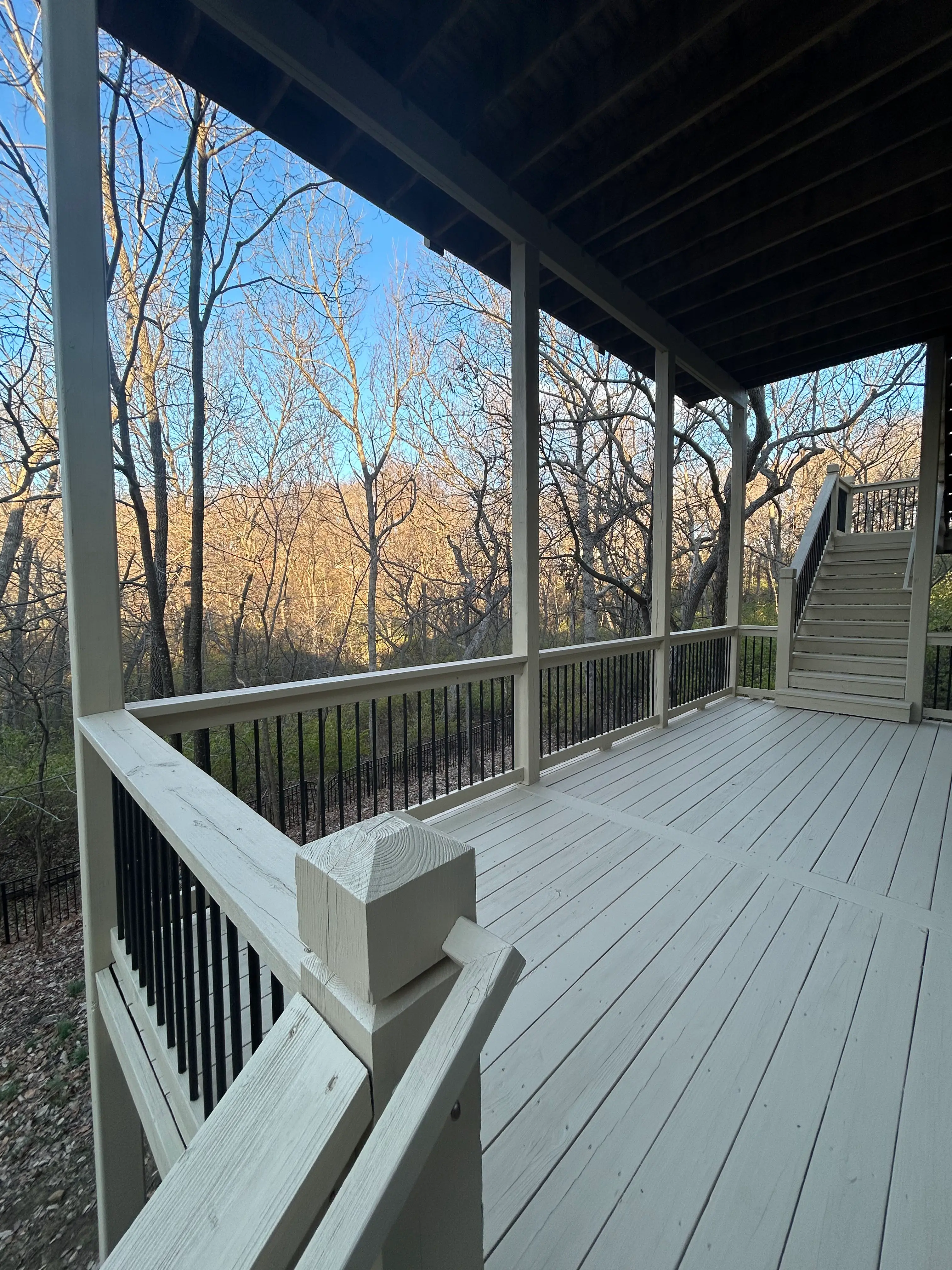 An image of the first level newly installed white deck looking toward the stairs.