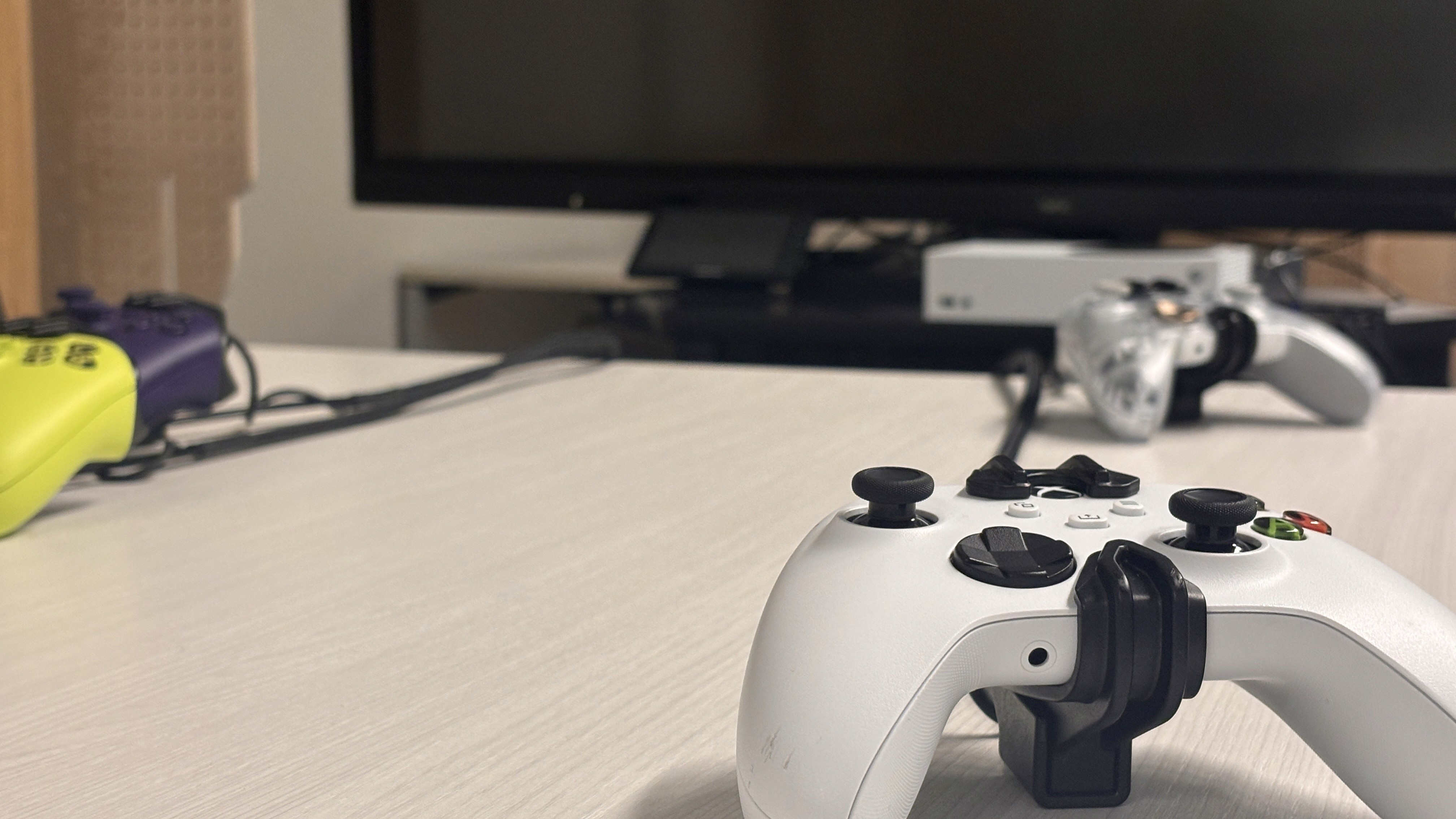 xbox controllers on desk infront of TV