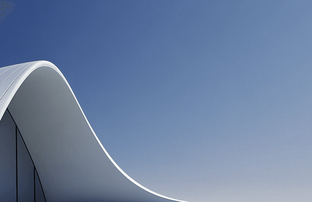 Curva arquitetônica branca e suave contra um céu azul gradiente, capturando a estética minimalista e moderna da estrutura.