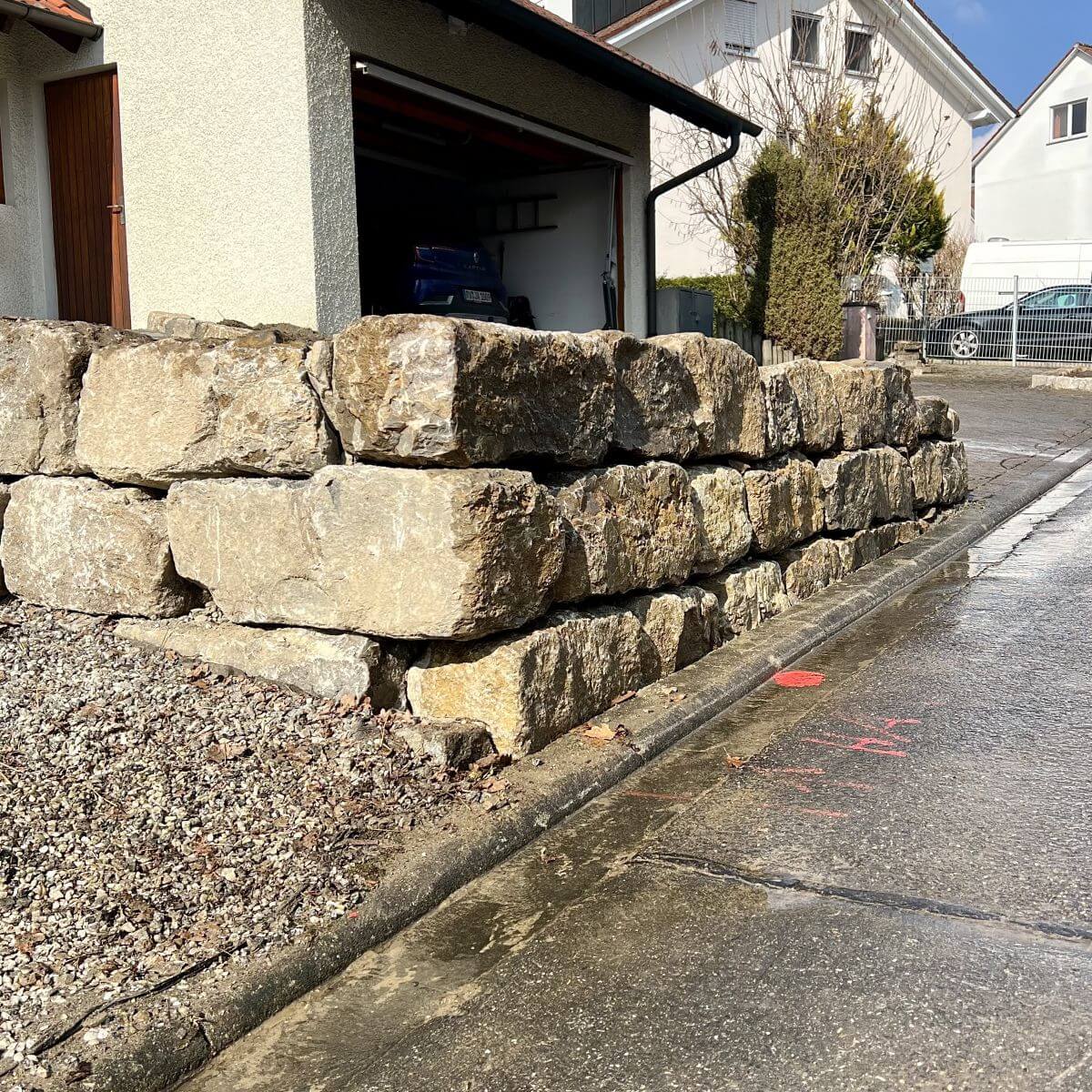Massive Natursteinmauer zur Hangsicherung in Ravensburg, gebaut für maximale Stabilität und natürliche Optik im Garten.