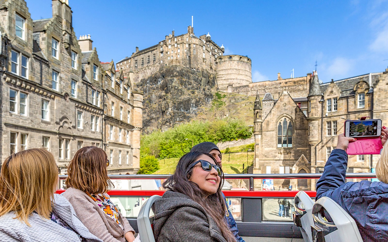 Turistas no ônibus hop-on hop-off perto do Castelo de Edimburgo durante o Royal Edinburgh Tour.