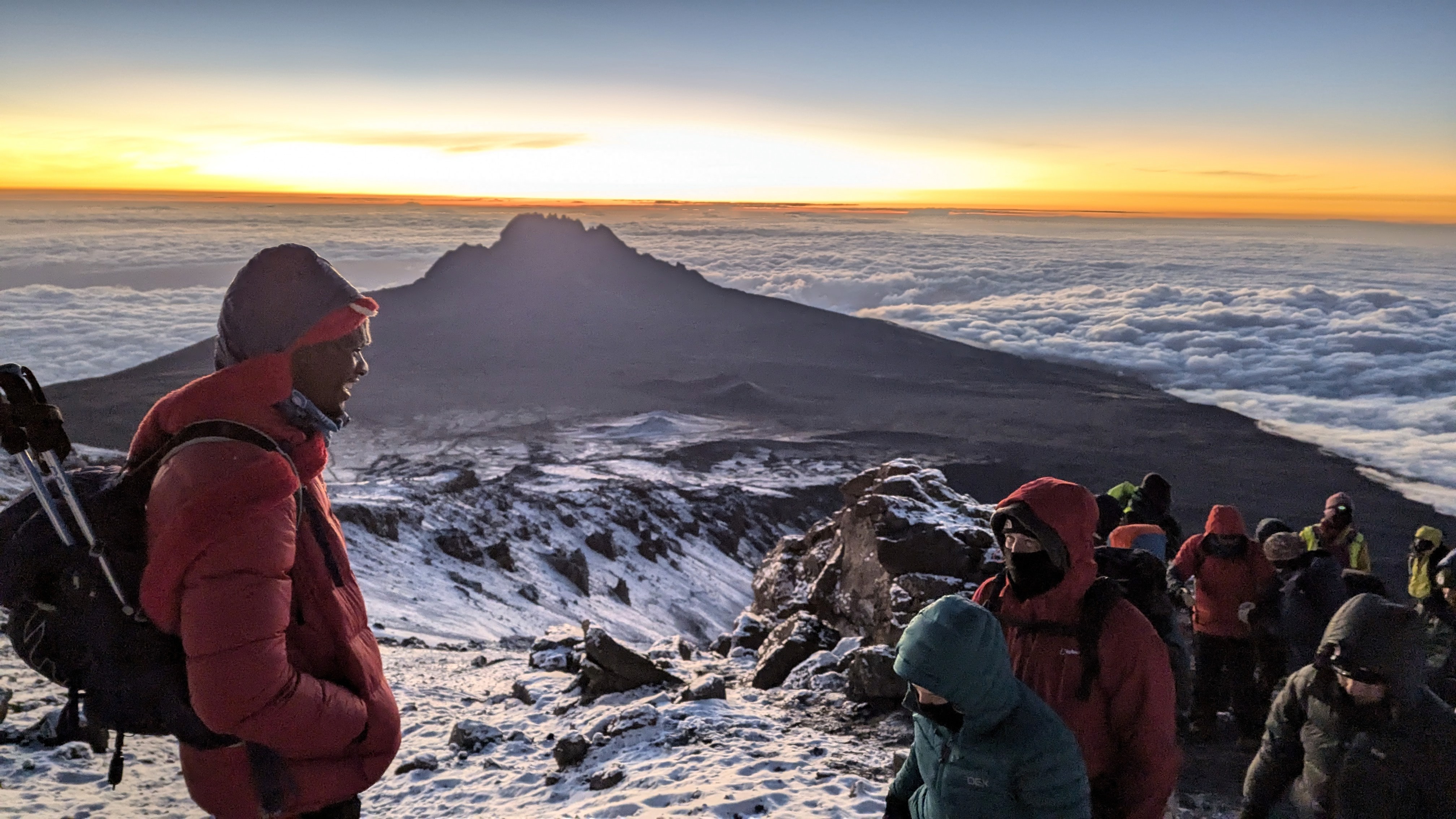 Climber at the Uhuru Peak summit sign on Mount Kilimanjaro, Tanzania