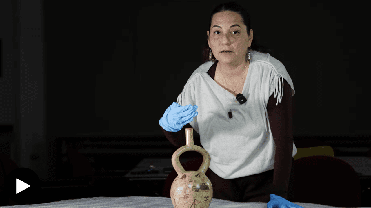 Solsiré Cusicanqui next to a stirrup-spout Moche vessel.