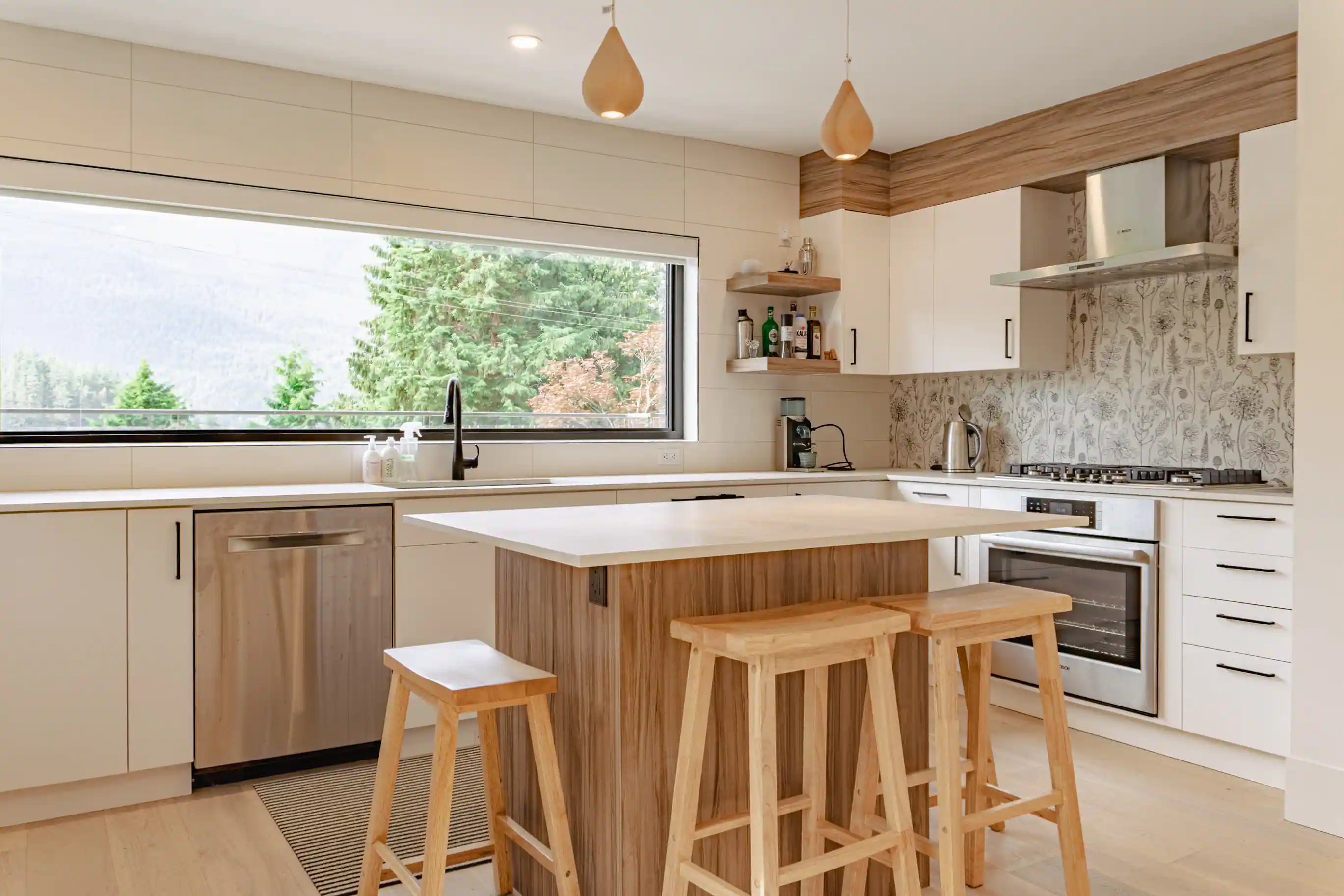 Modern custom home kitchen interior with wood cabinetry, island seating, and large window
