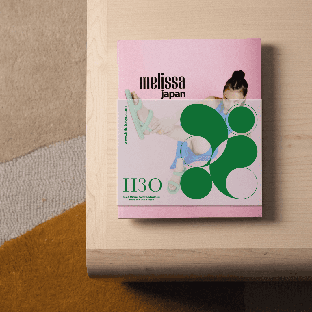 H3O colorful circular logo printed on a tracing paper wrapping on a fashion magazine layout, part of the Tokyo high fashion curator identity designed by Josephine Grenier.
