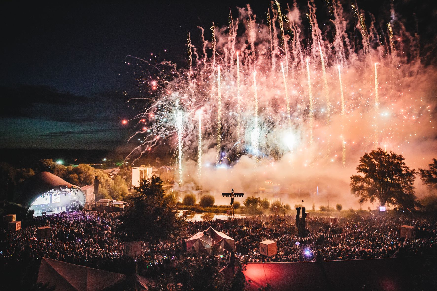 Corporate festival event at Secret Garden Party with outdoor stage, large audience and fireworks at night
