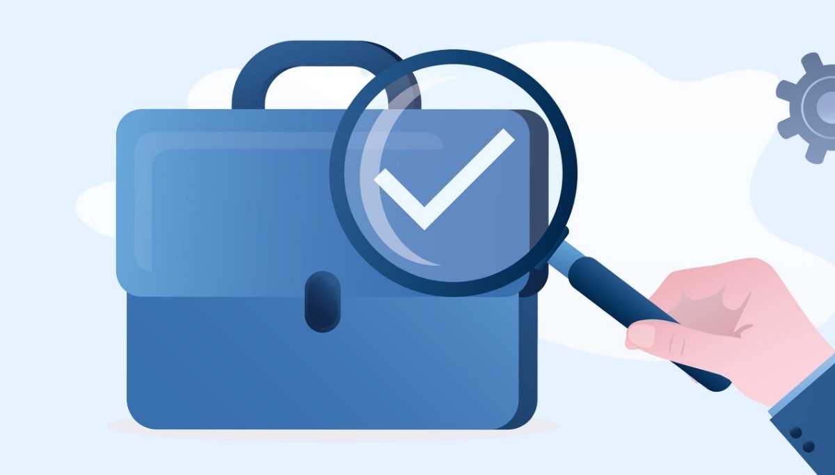Illustration of a blue briefcase under a magnifying glass with a checkmark—symbolizing employment verification, job search evaluation, and the criteria that determine benefit eligibility during unemployment.
