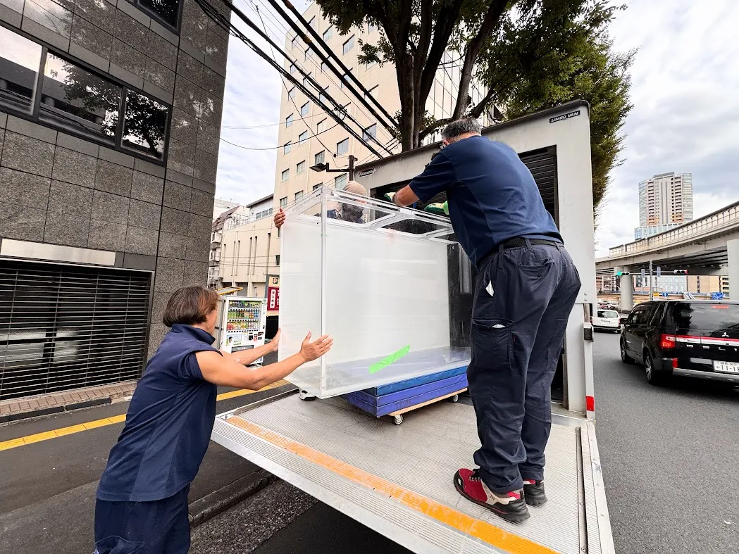 大型アクアリウム水槽をトラックに積み込む搬入作業の様子