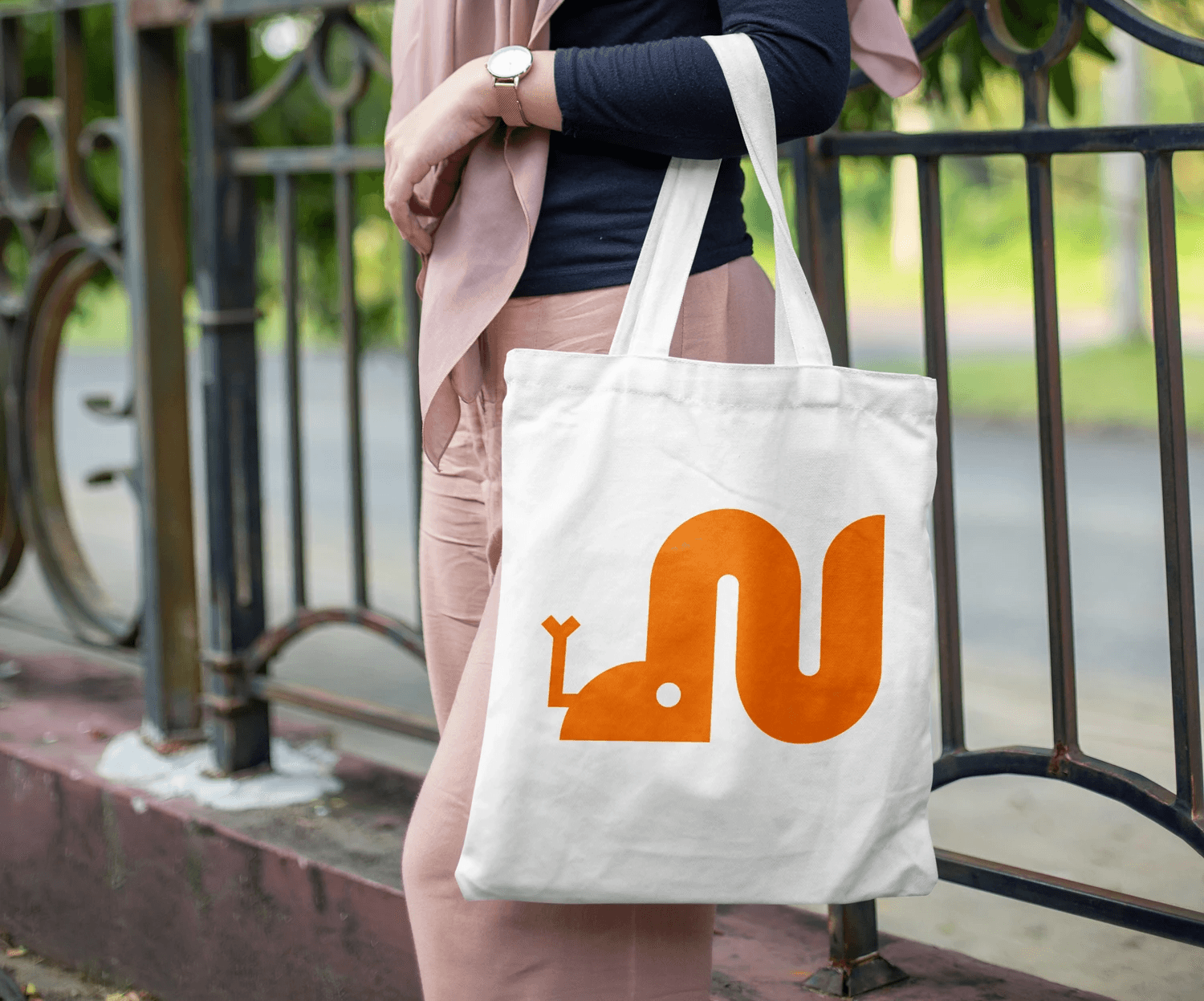 a woman holding a tote bag outdoors