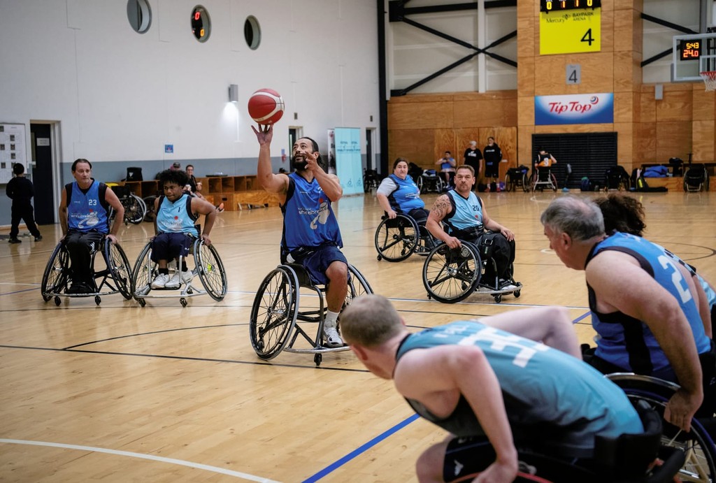 A wheelchair basketball team playing with a player taking a shot