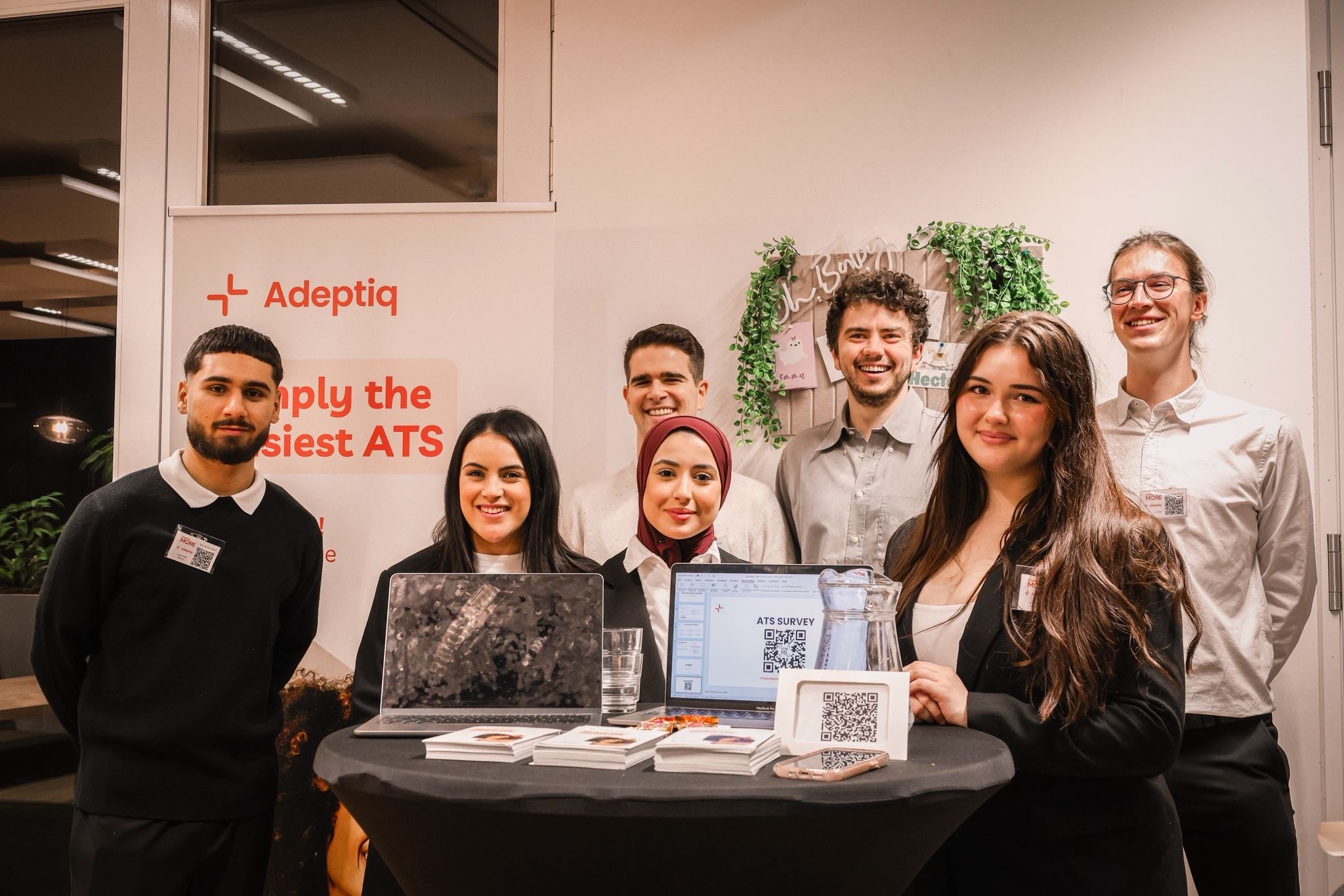 A group of students and the Adeptiq team in front of an Adeptiq banner, showing the Adeptiq prototype