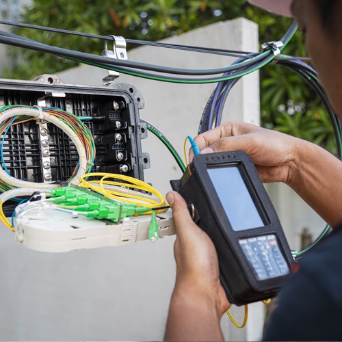 Security installer checking connections on newly installed equipment.