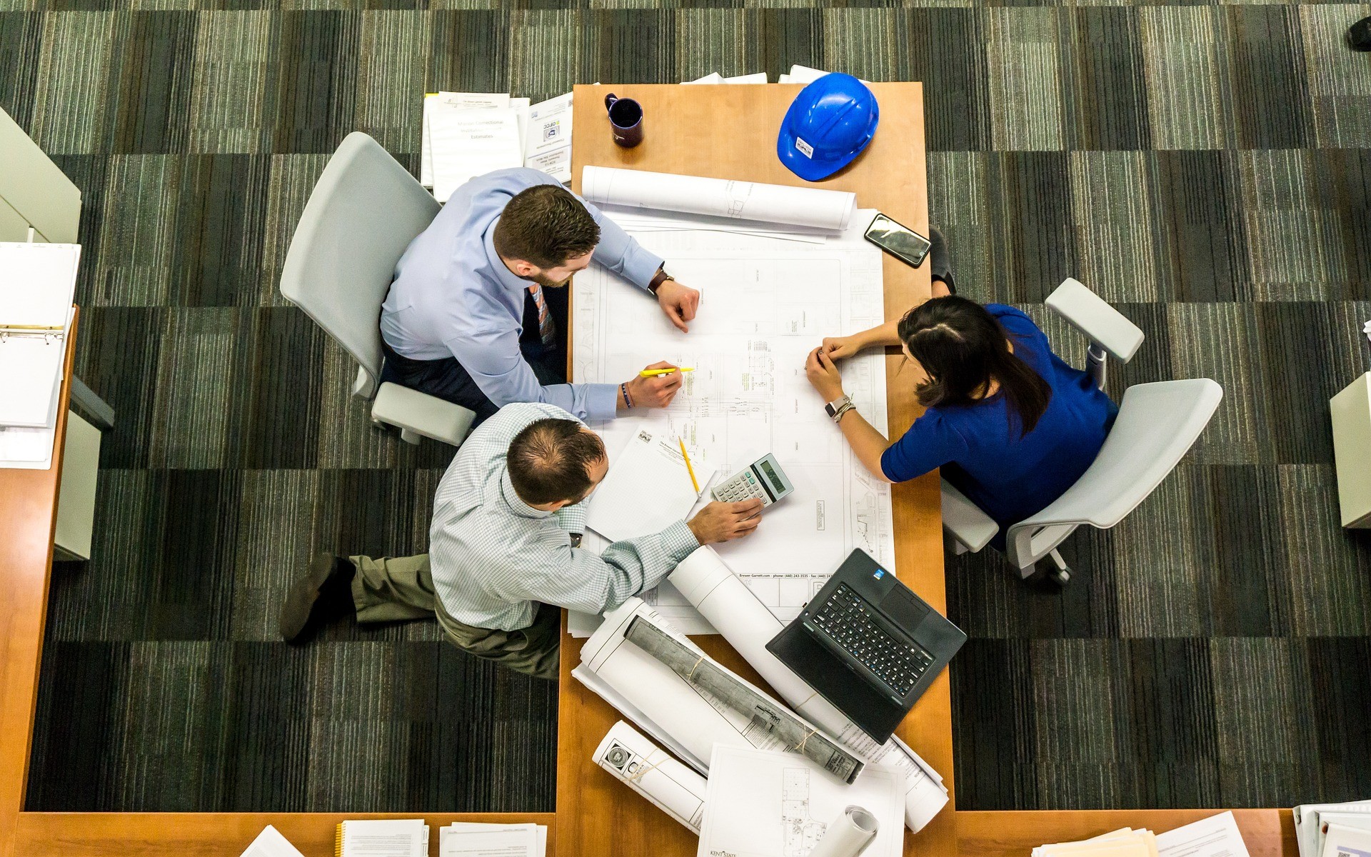 Interior architect reviewing building plans using NormA for compliance management.