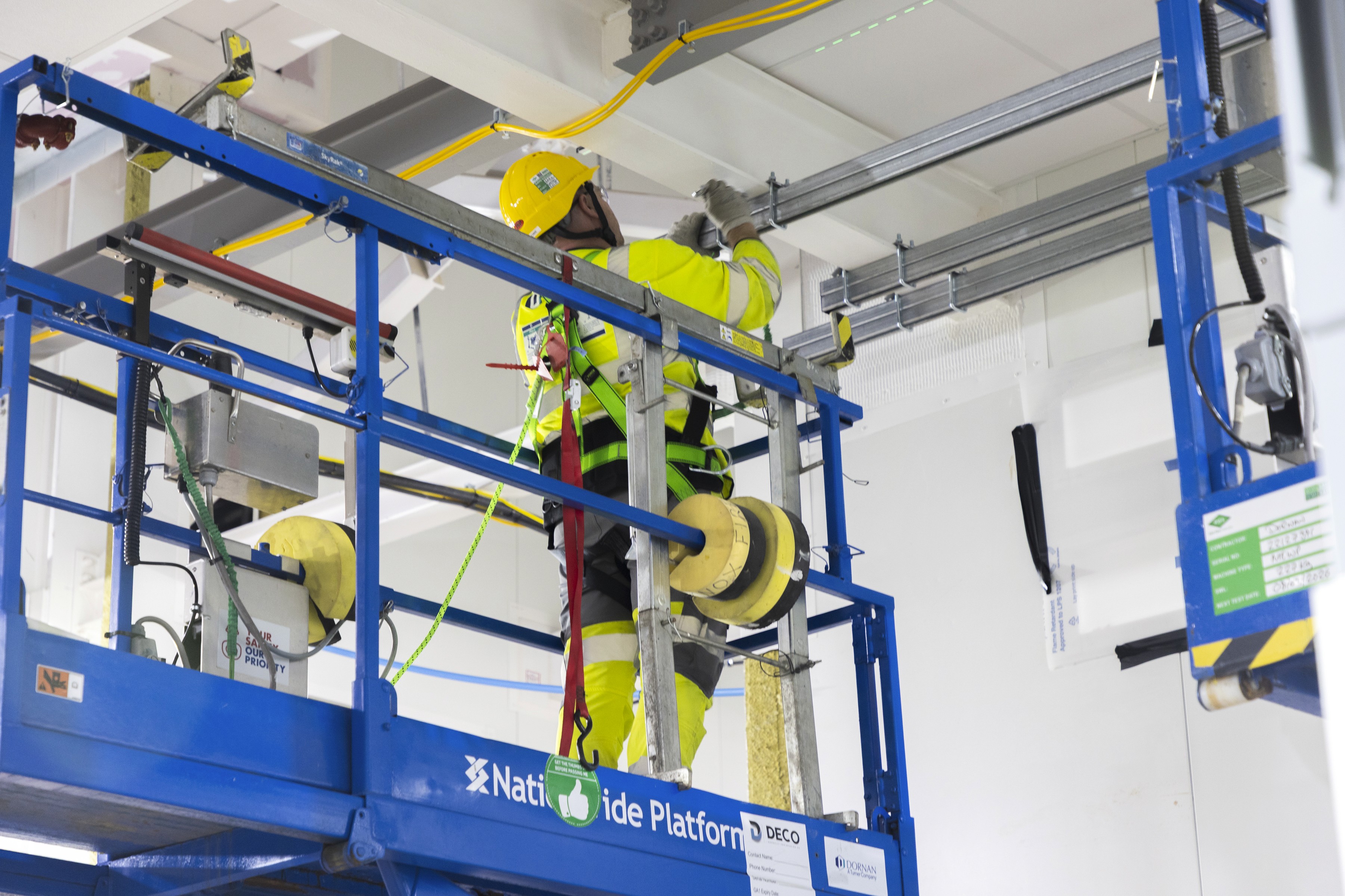 Modern glass building with illuminated interior and reflections at sunset