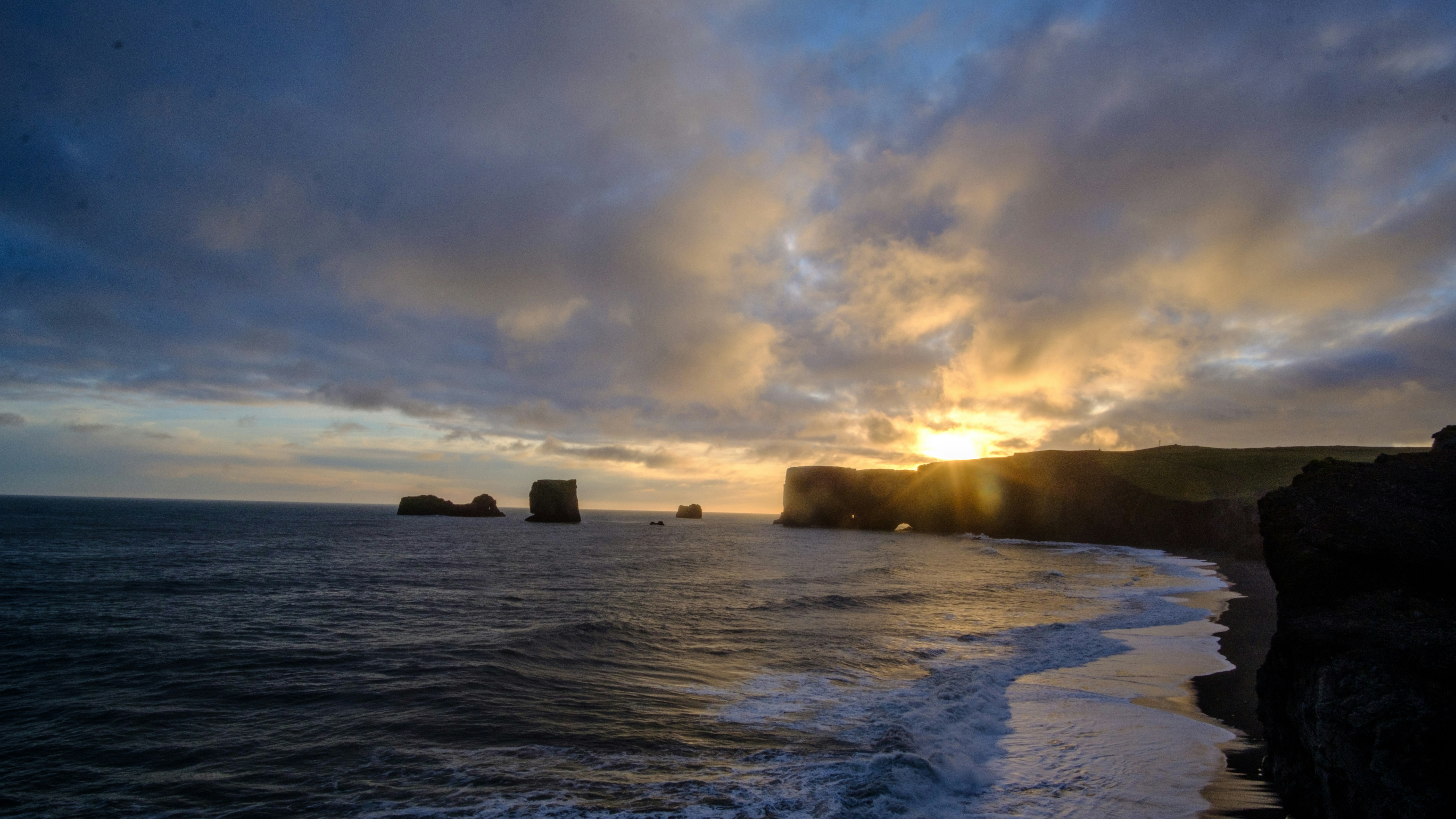 Sun setting behind Dyrhólaey in Iceland.
