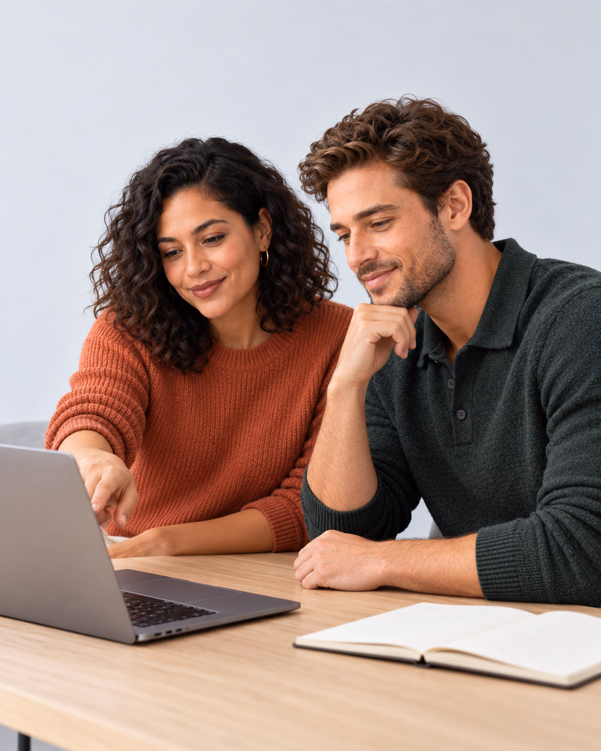 Two designers reviewing work together on a laptop