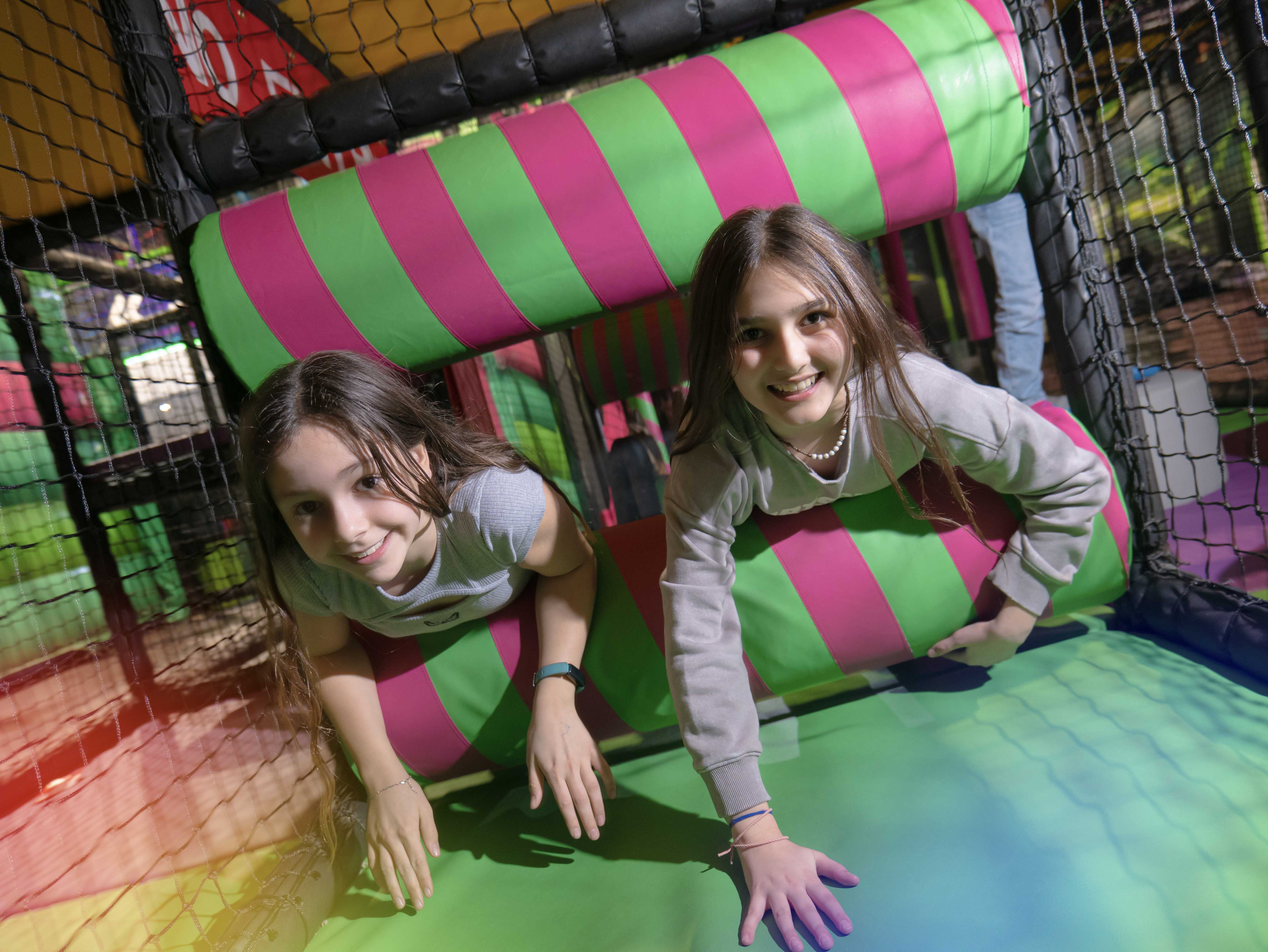 young girl and boy climbing through soft play area at Flip Out Adventure Park