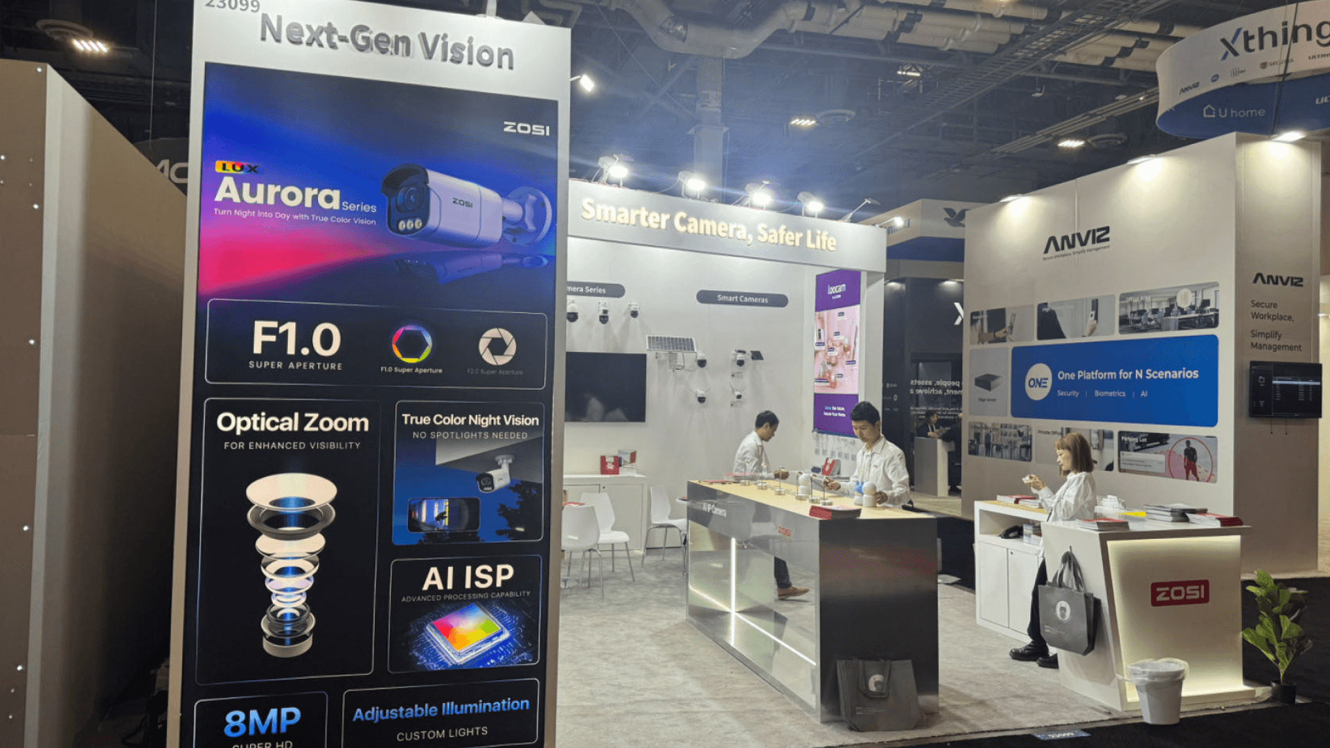 ZOSI ISC West 2024 20x20 smart surveillance booth at The Venetian Expo with product feature tower, Aurora camera graphic, and side-entry visibility
