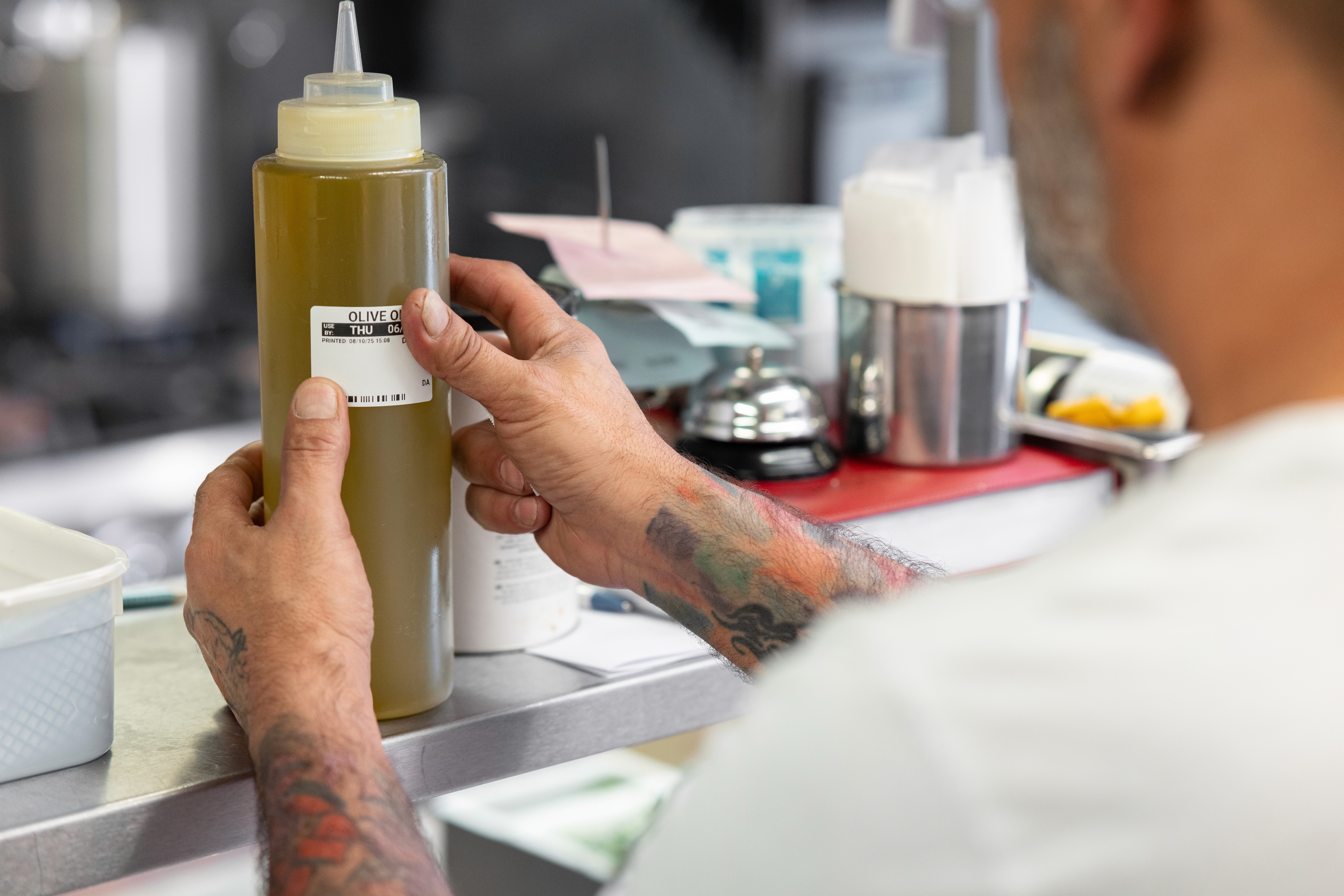 Chef sticking label onto oil.
