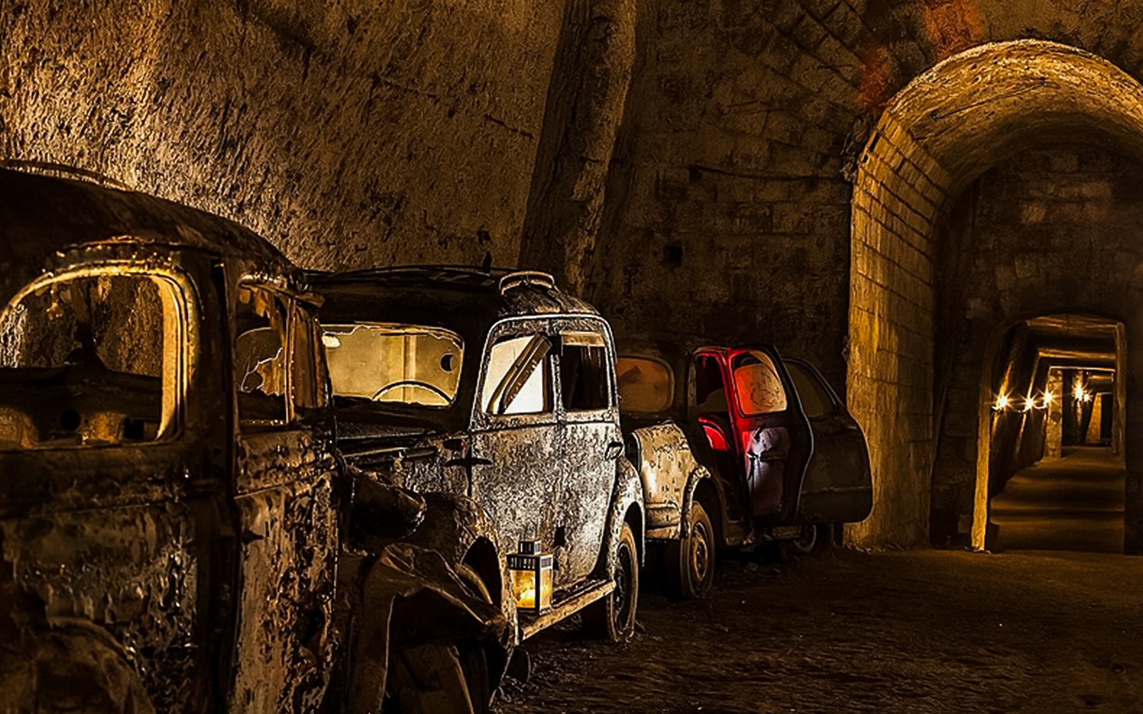 Verlaten vintage auto's in de schemerige Bourbon Tunnel, Napels.