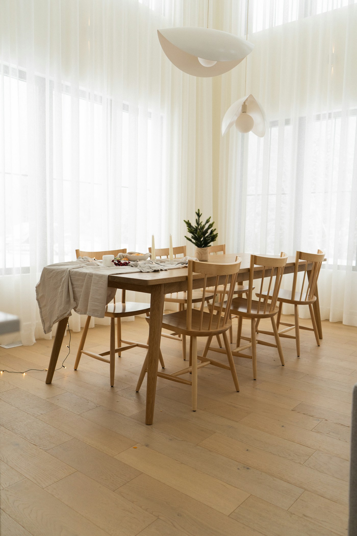 Dining room in oak with sheer curtains along the window wall