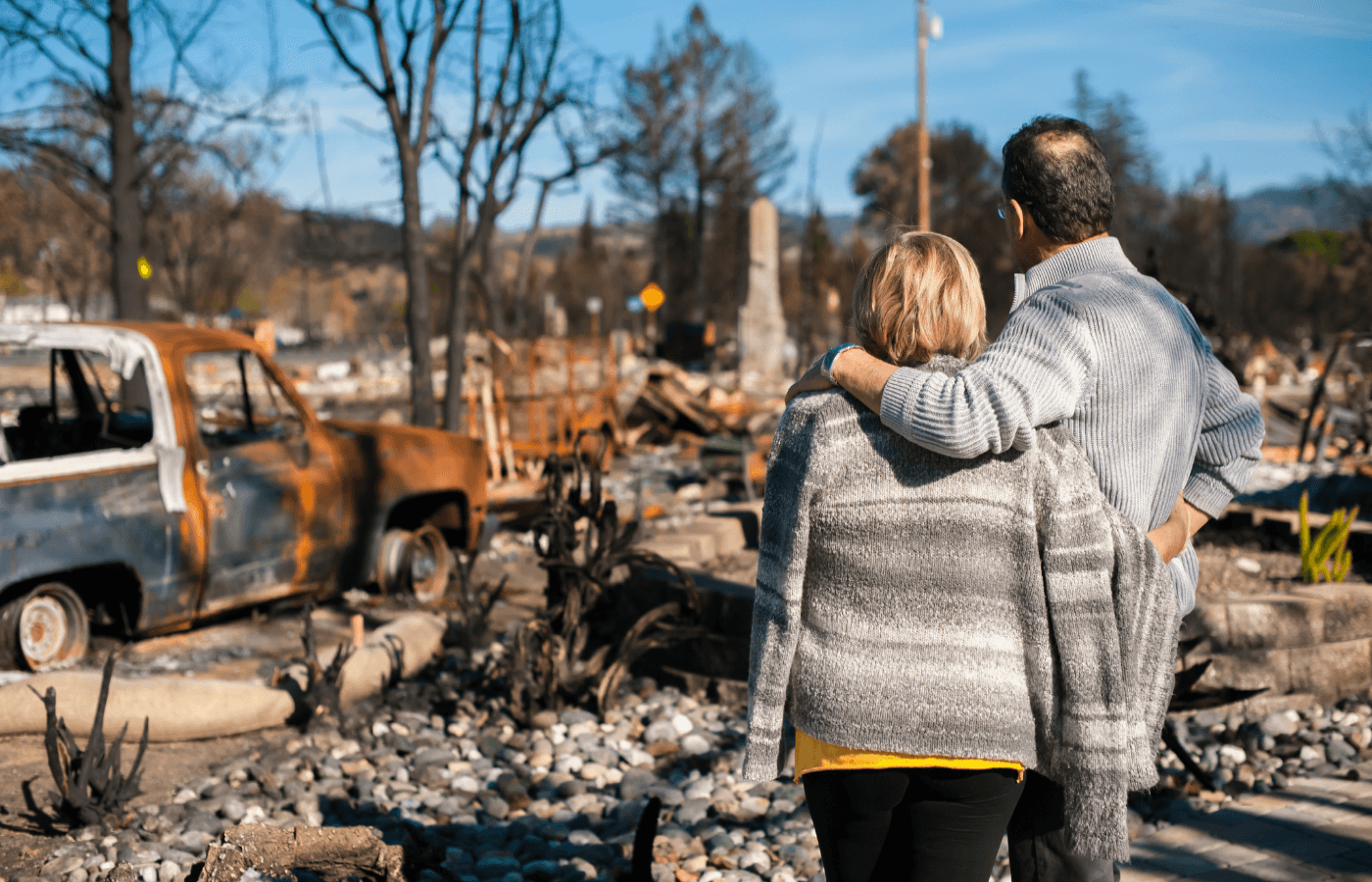 couple looking at a destroyed house