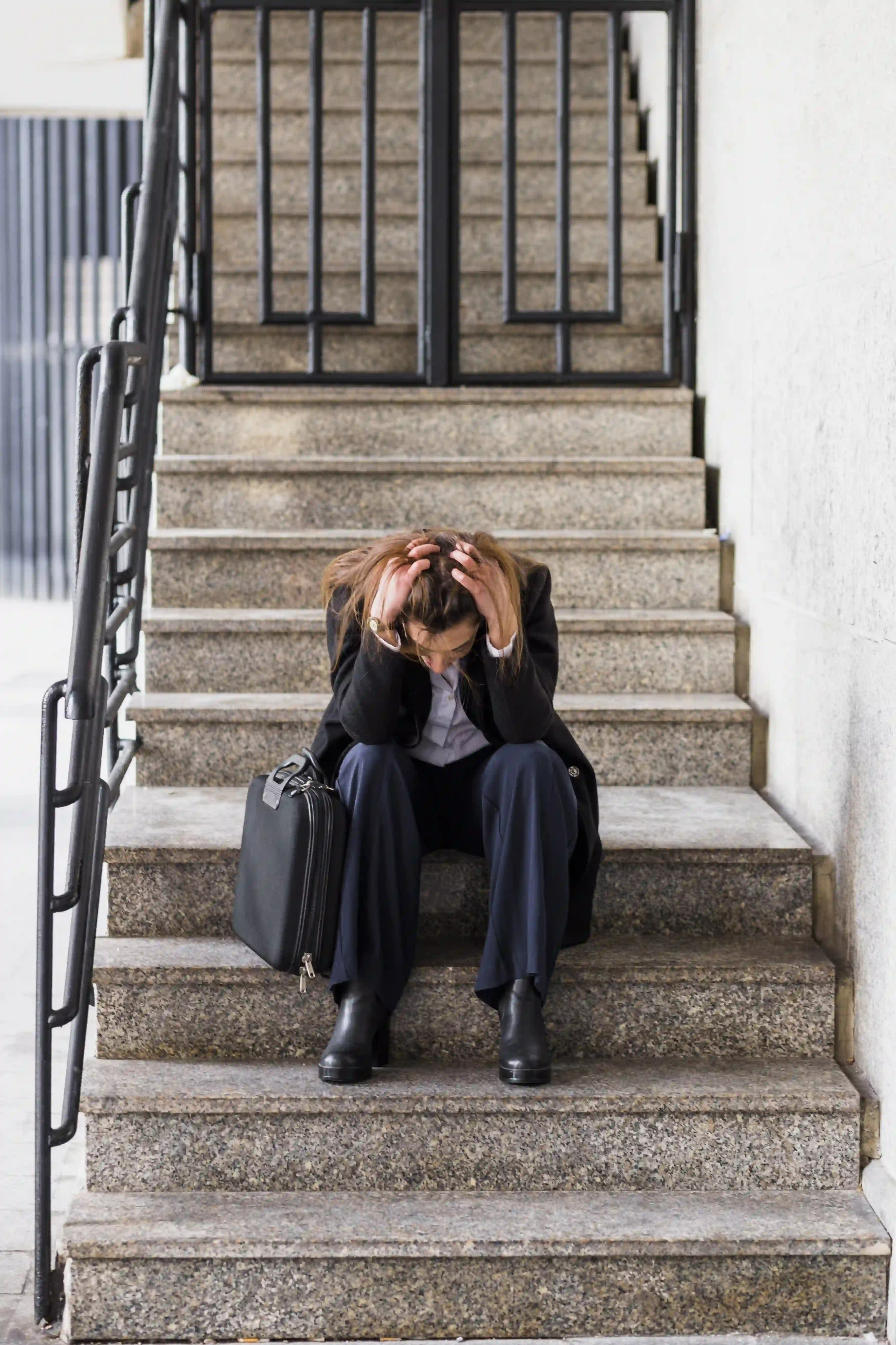 başarısızlık korkusu yaşayan ve stresli hisseden kişinin merdivende oturması