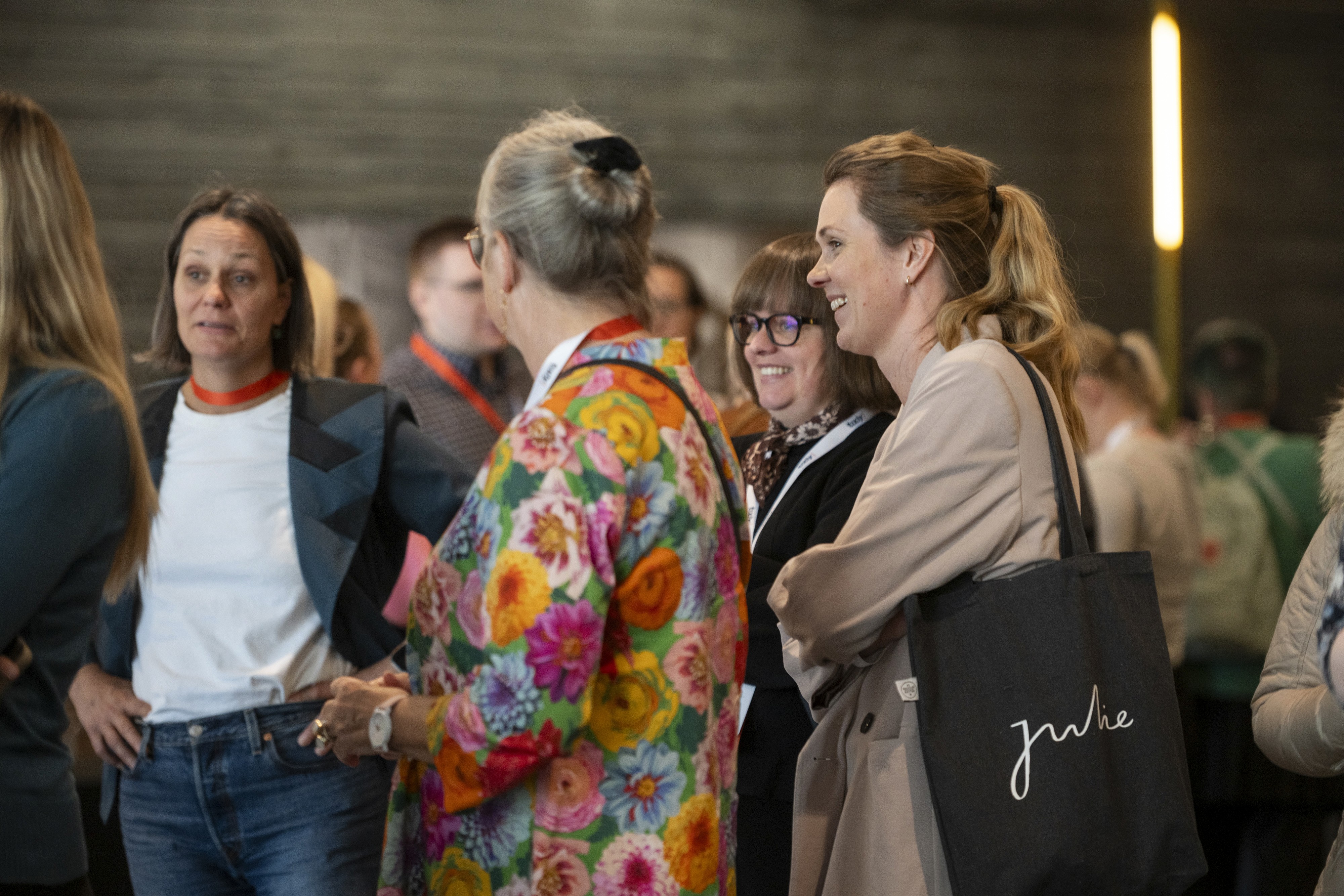 A group of people in a casual setting, engaged in conversation and wearing colorful clothing.