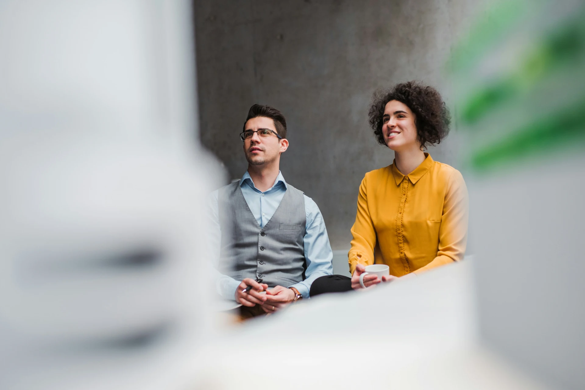 Two colleagues listening to a presentation