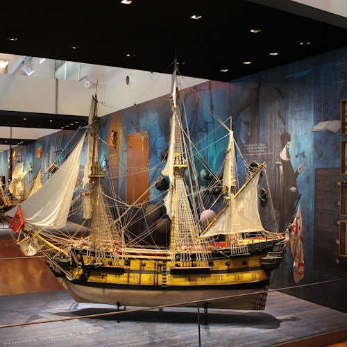 一個詳細的帆船模型，擁有黃色和黑色的船體，展示在海事博物館的展覽中。