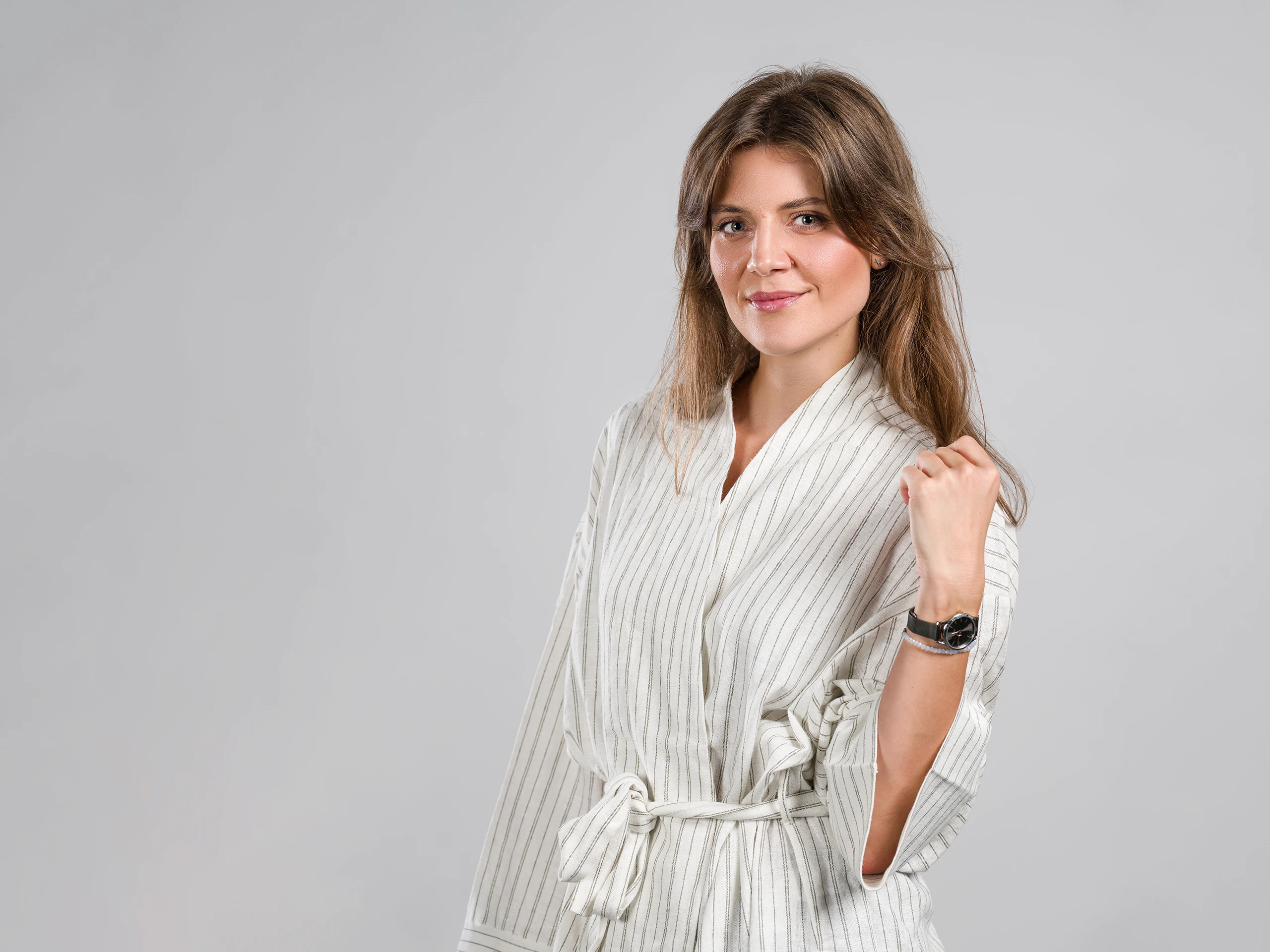 Corporate lifestyle portrait of a woman in a relaxed pose, captured naturally in a studio.