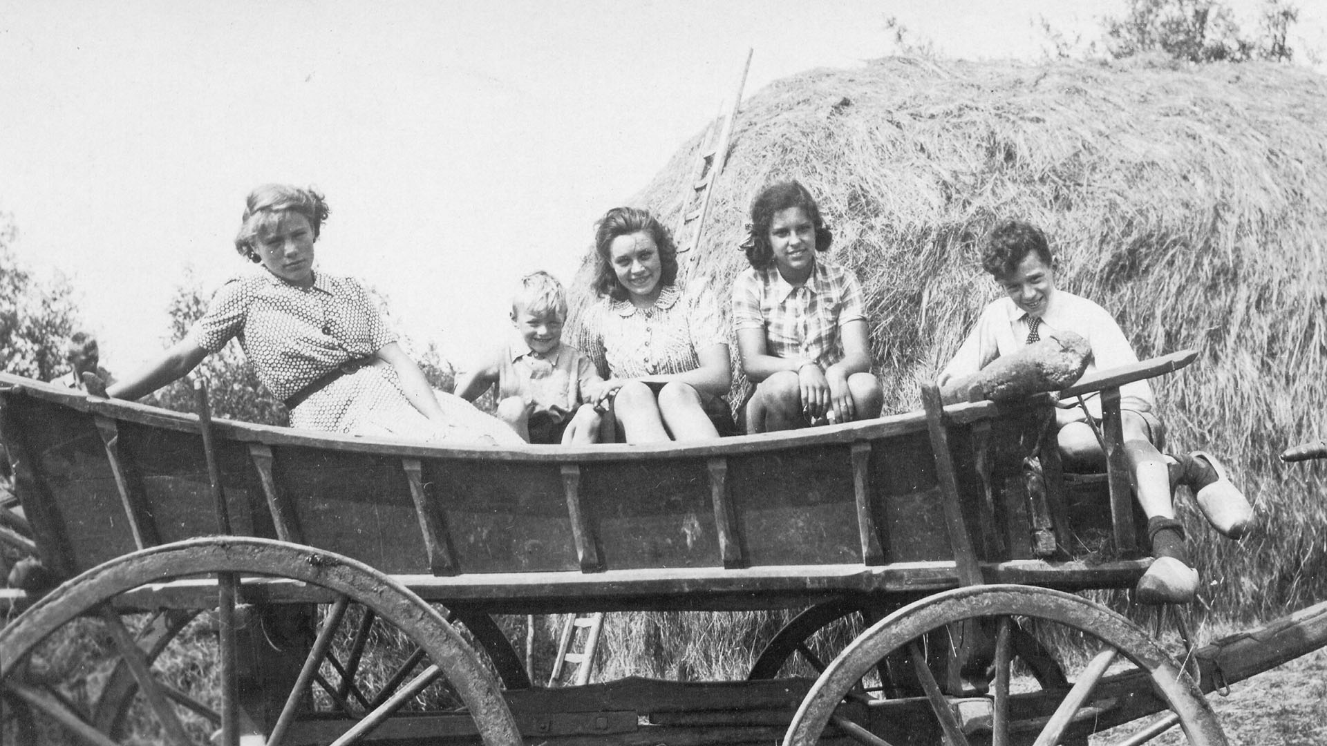 Blokland expositie Evert van Woudenberg steekt hooi op. Evert jr loopt met het paard. Op de wagen Wim van Arregon - Stichting Oud Montfoort