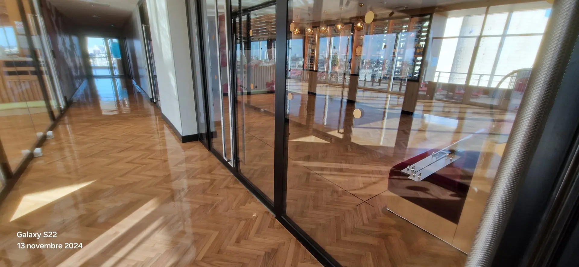 Parquet à motif dans un espace vitré, photographié dans la galerie de rénovations Aliénor Parquet