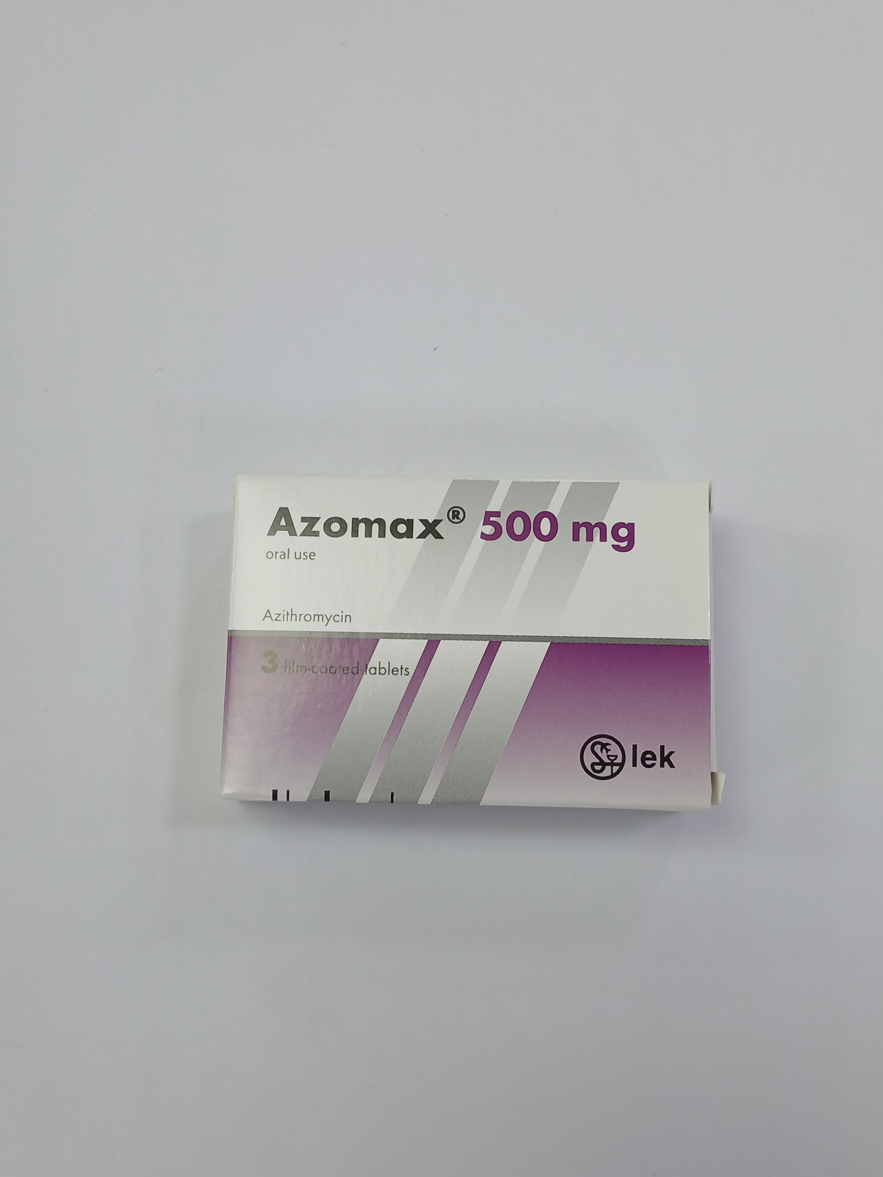 A white cardboard box for medication, labeled "Azomax® 500 mg" in dark grey and purple text, with "oral use" and "Azithromycin" in smaller text, and "3 film-coated tablets" in light grey, is centered on a plain white background.