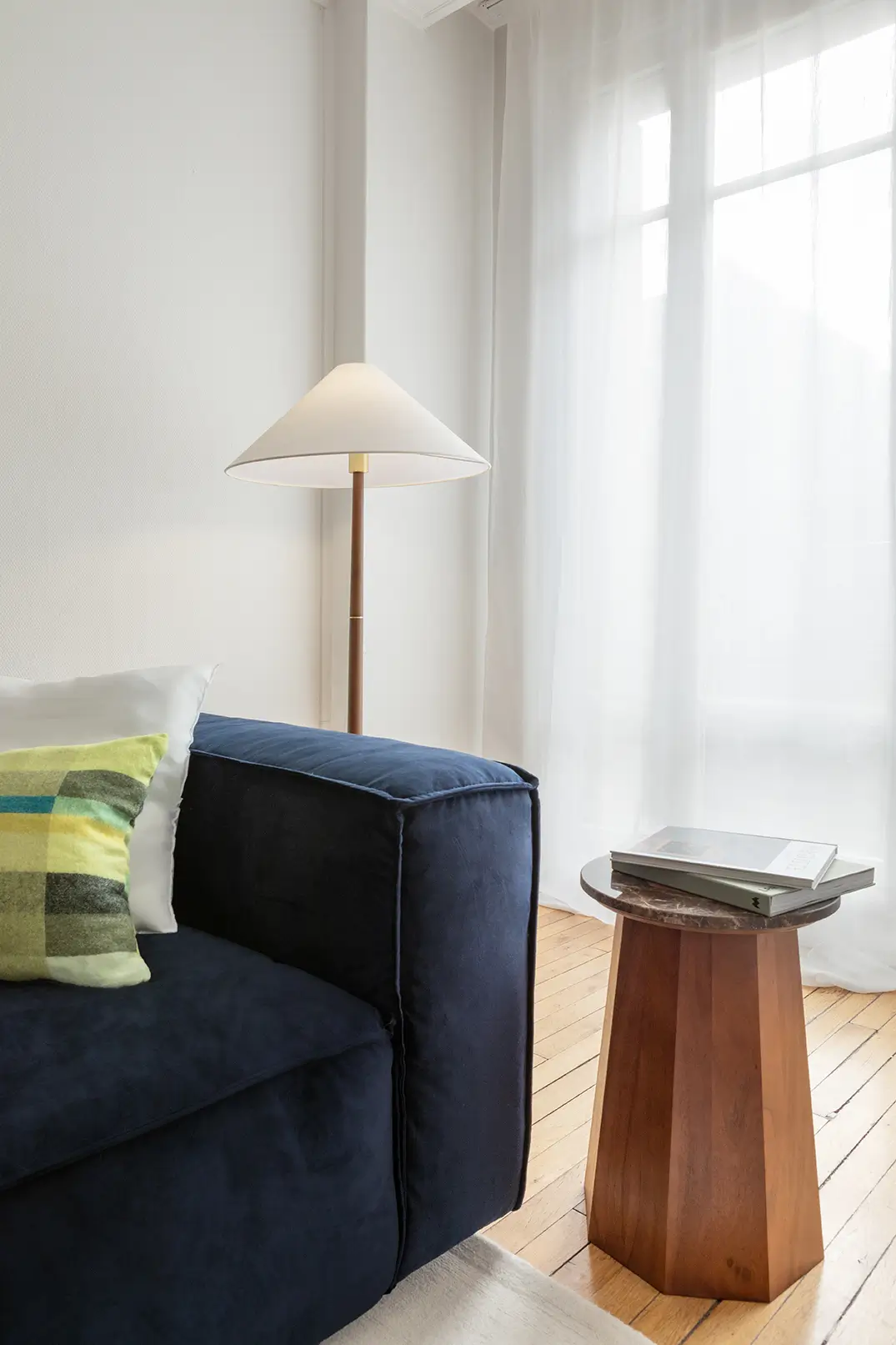 Un canapé bleu nuit avec une lampe.