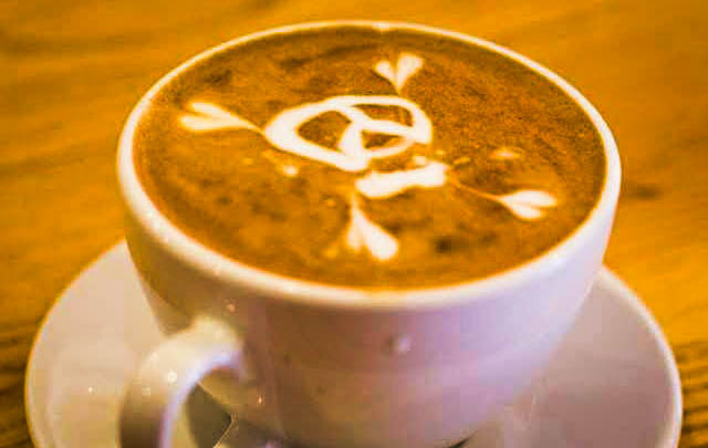 a latte with a skull and cross bones on it