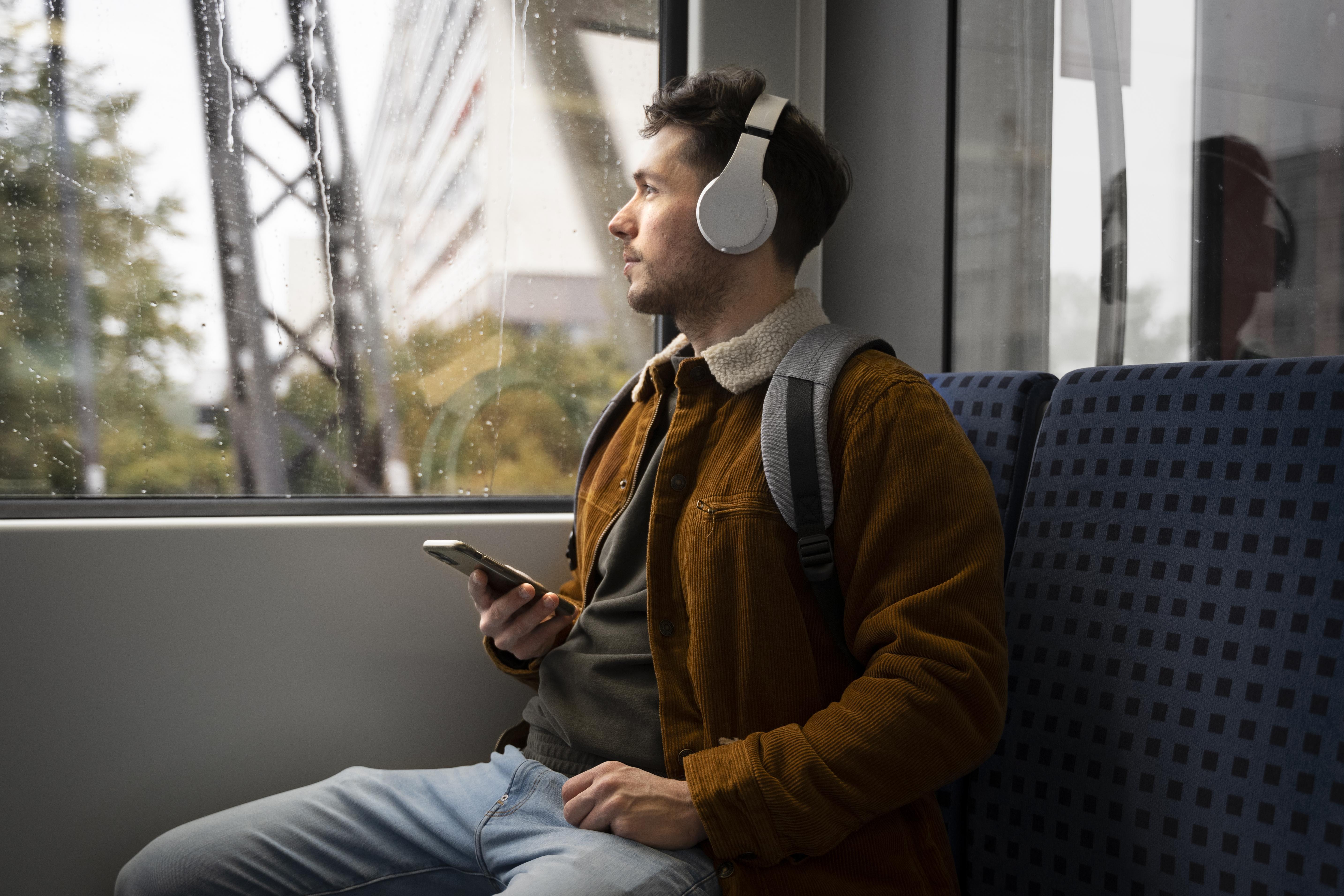 Man in train listening to music
