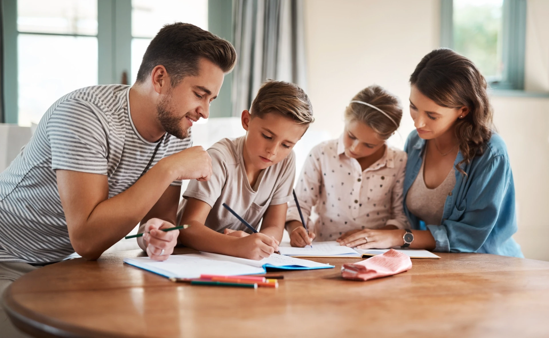 Une famille se réunit autour d'une table, participe à des activités et partage des idées avec du papier et du matériel.