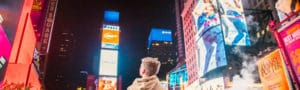 man standing on road infront of high-rise buildi