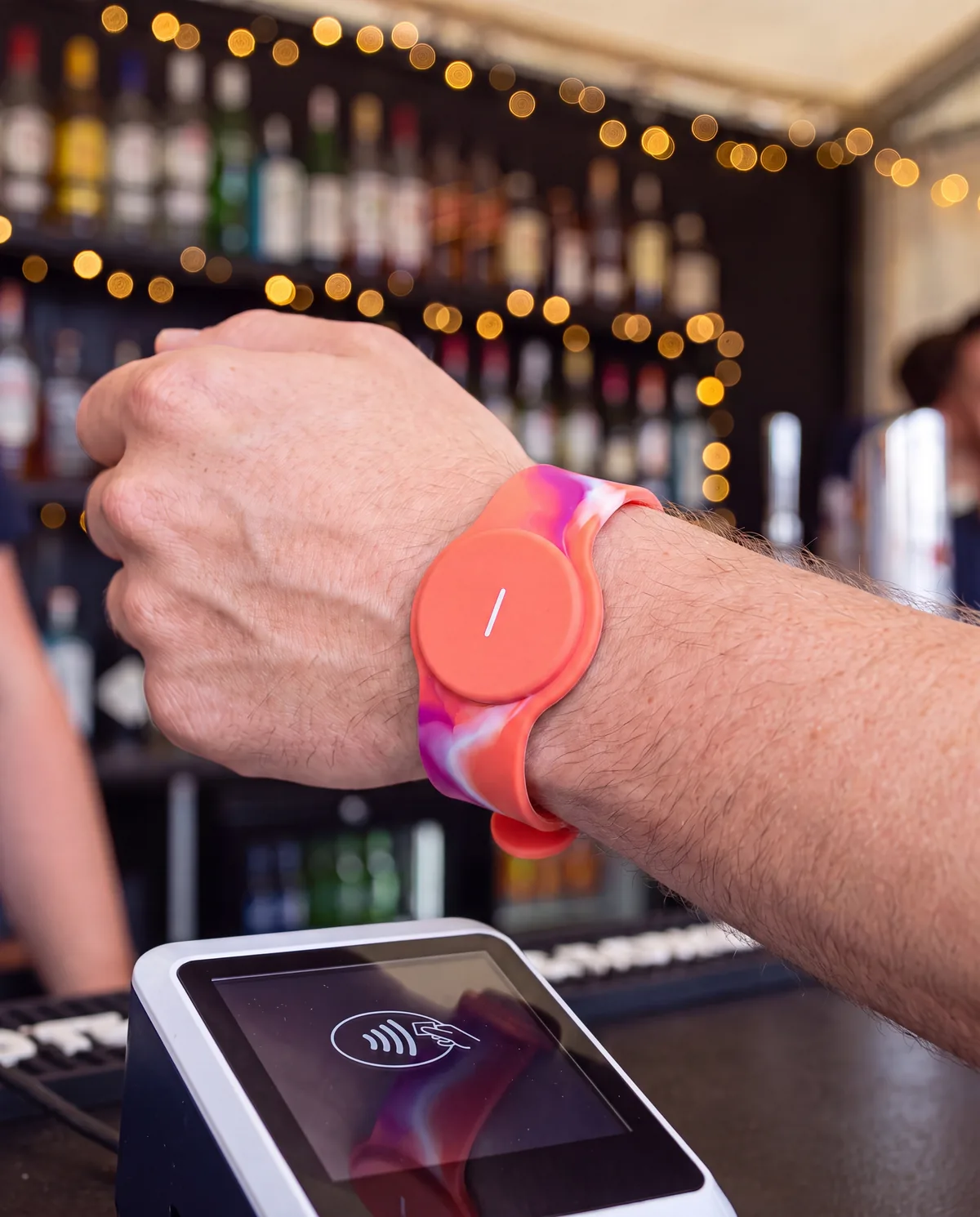 RFID silicone wristband making a contactless payment at a festival bar