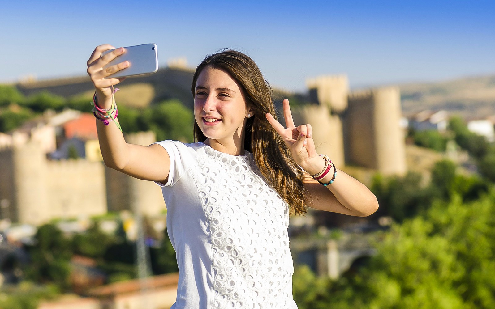 Persoon die een selfie maakt met de stadsmuren van Ávila op de achtergrond tijdens de dagtrip naar Segovia & Ávila.