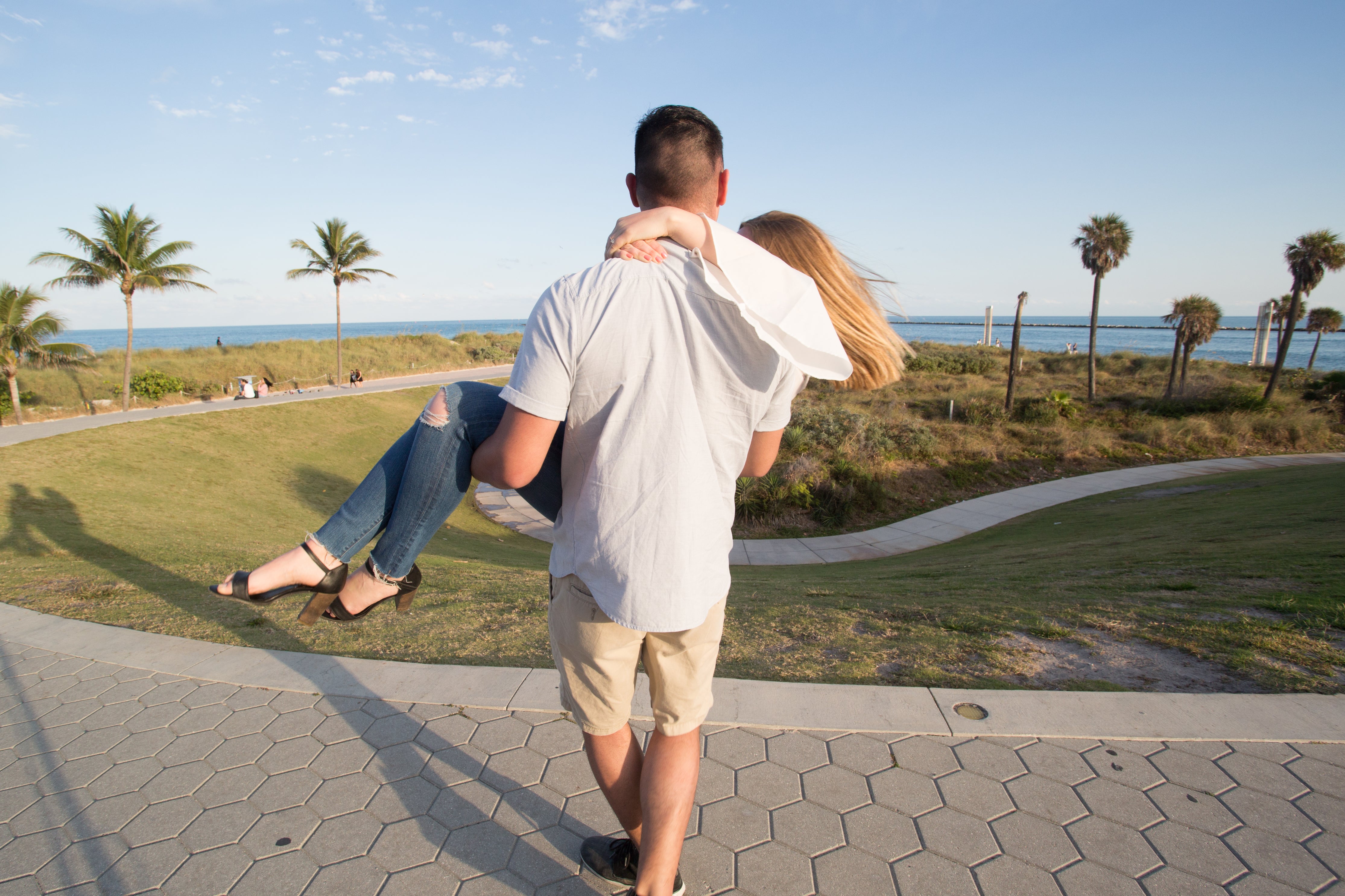 man carries a woman in a park