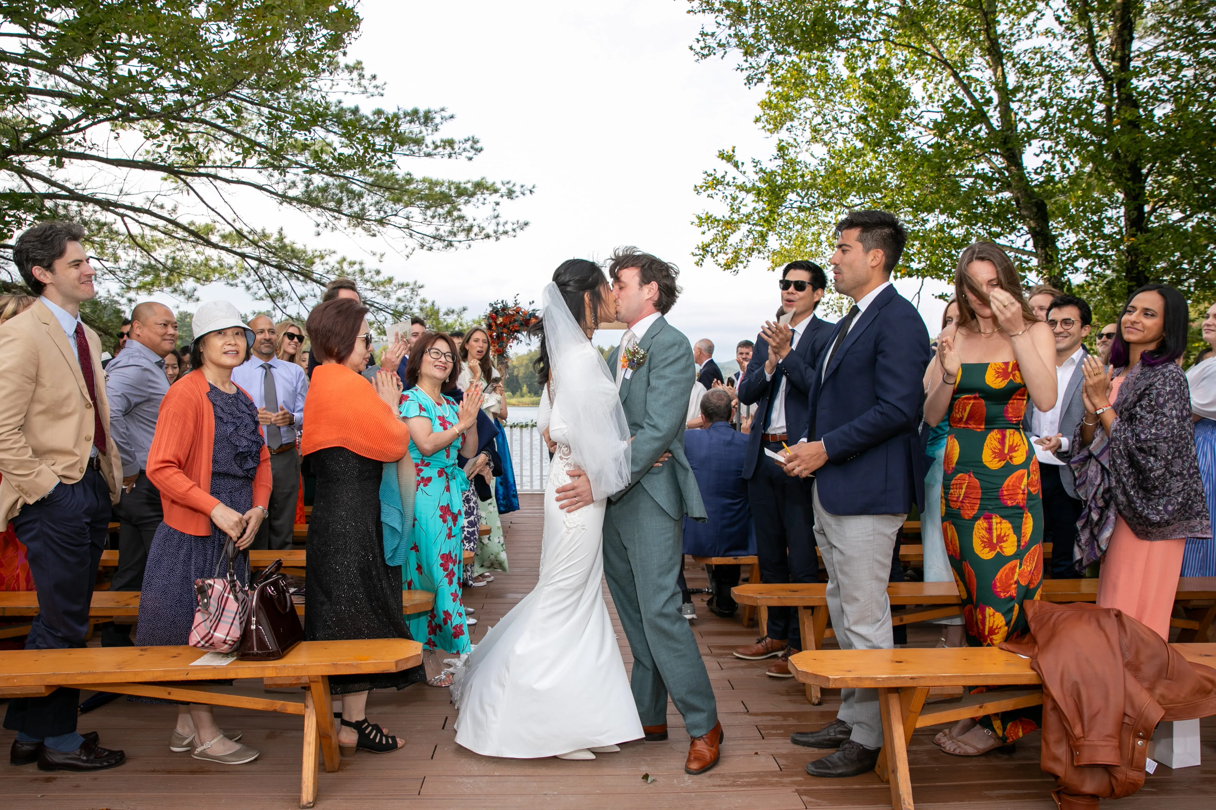 Newlyweds kissing after their lakeside ceremony at Camp Lenox