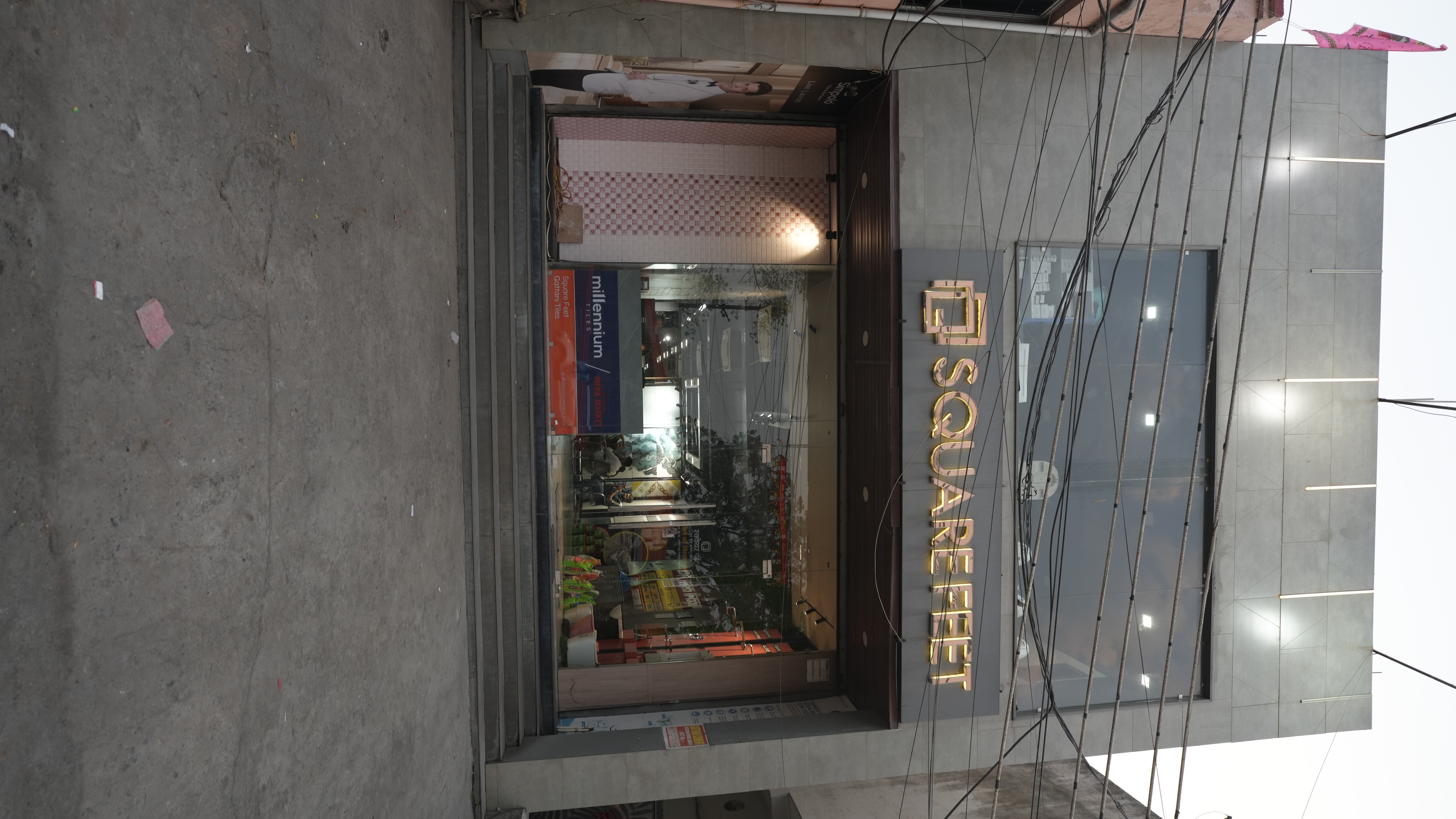 A serene outdoor seating area with two chairs, surrounded by lush greenery and a glassed-in structure.