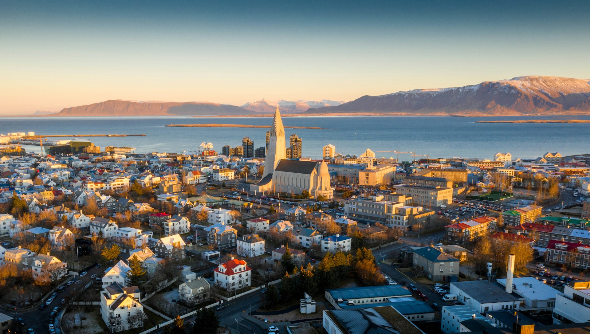 Hallgrímskirkja rising above downtown Reykjavík with Mount Esja across the bay.
