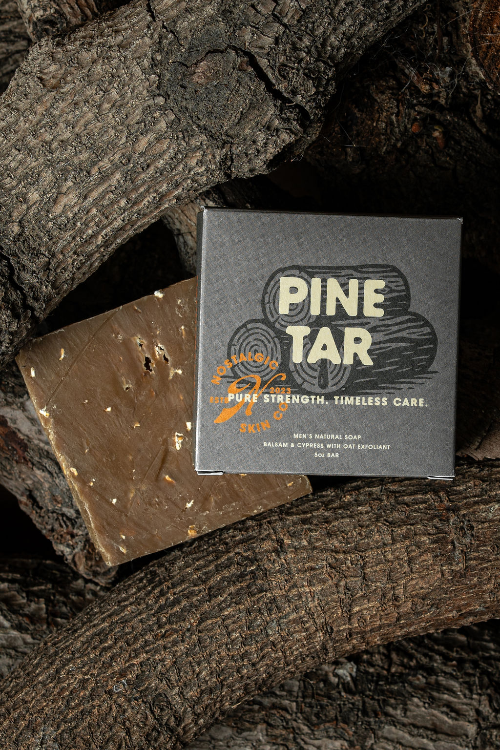 Pine Tar soap packaging resting on natural wood