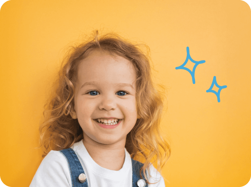 Smiling young child in KinderCare learning environment with sparkle graphics